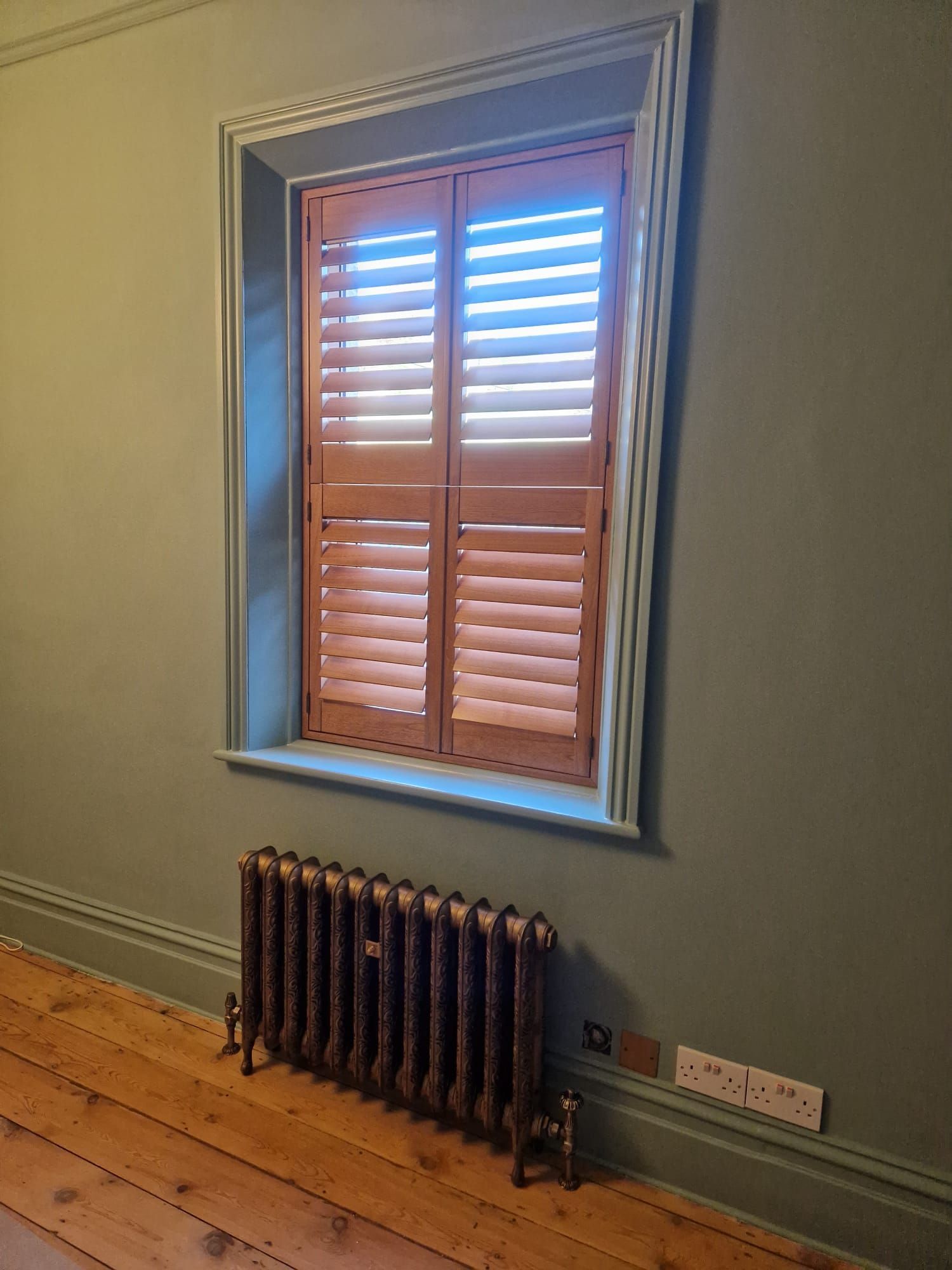 A room with a window and a radiator on the floor.