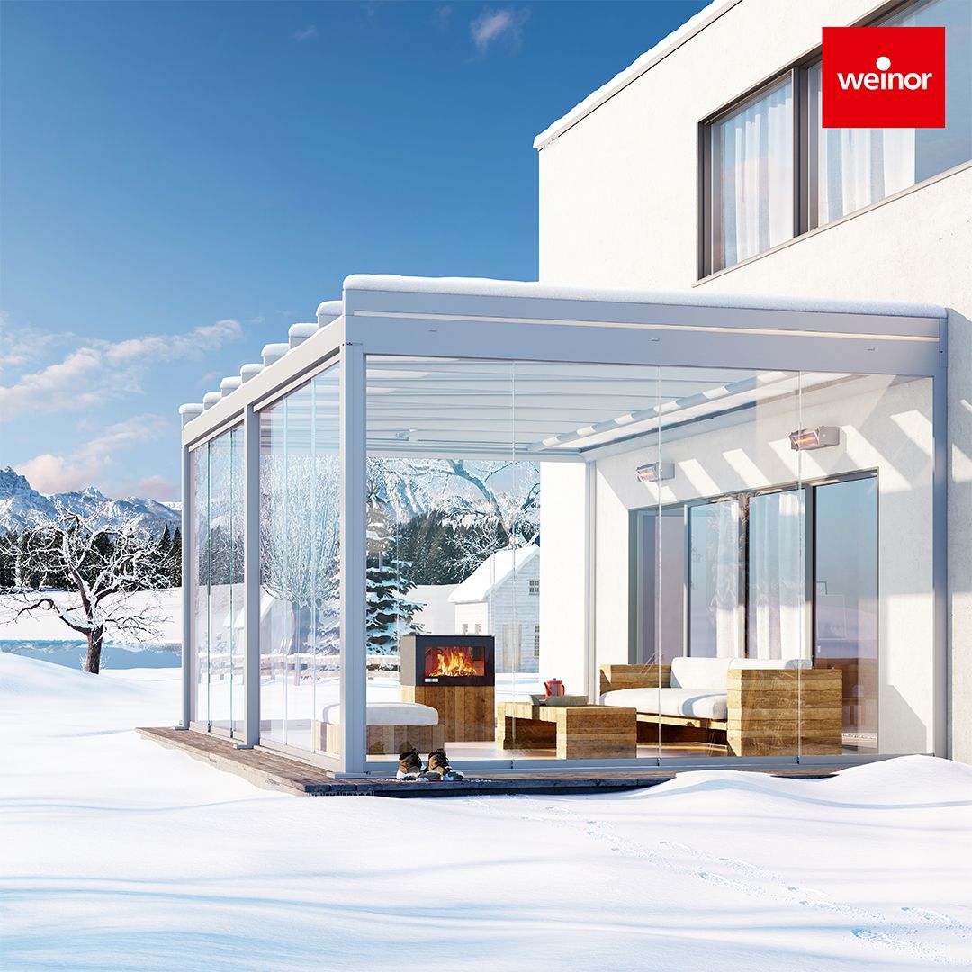 A white house with a pergola in the snow