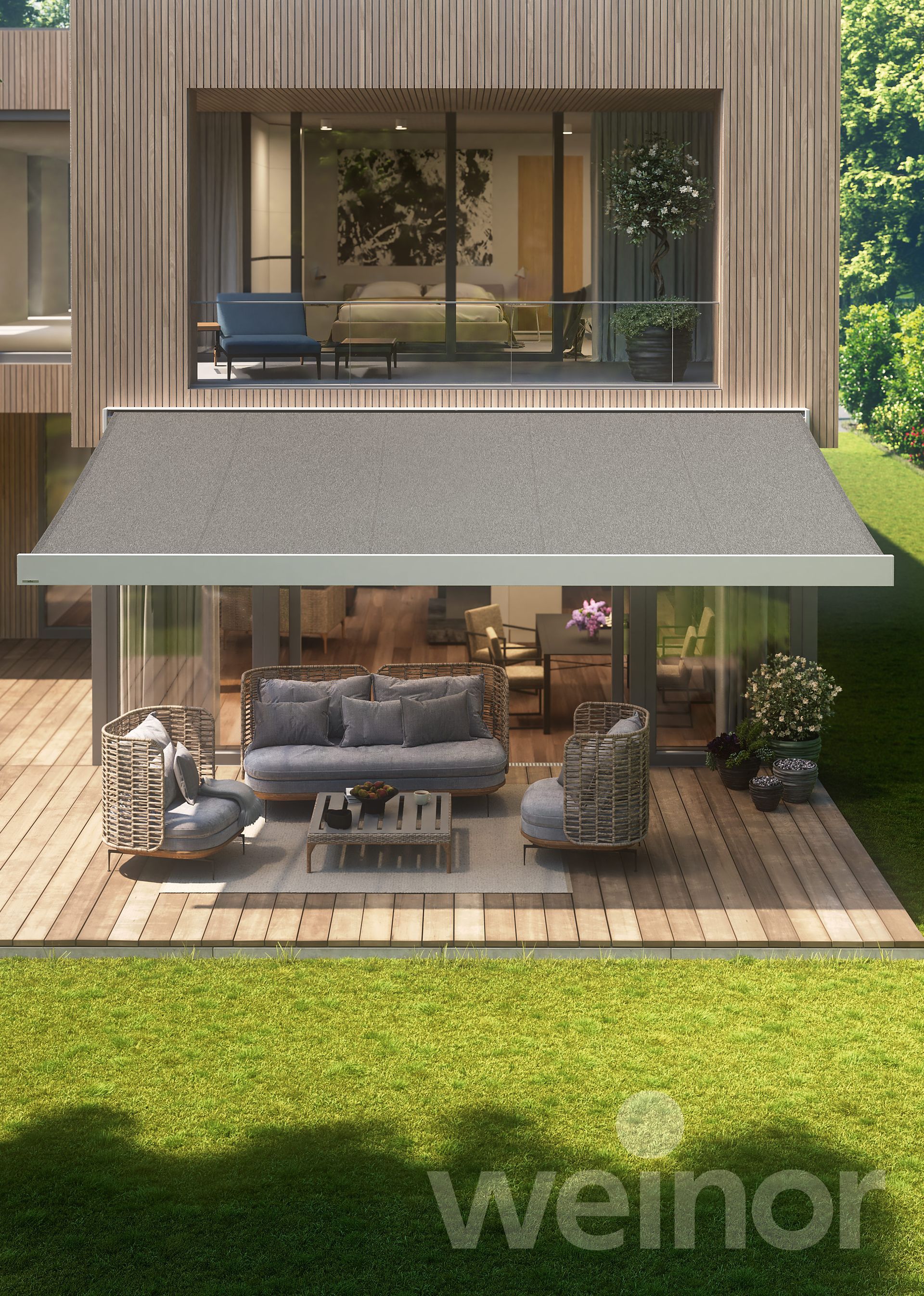A house with a patio with a couch and chairs under an awning.