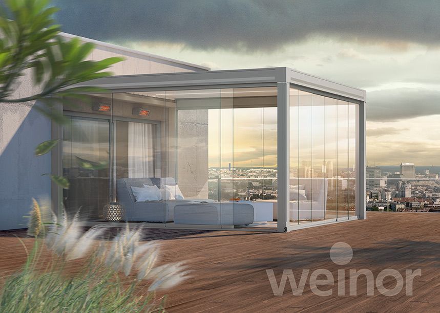 There is a pergola with sliding glass doors on the roof of a building.