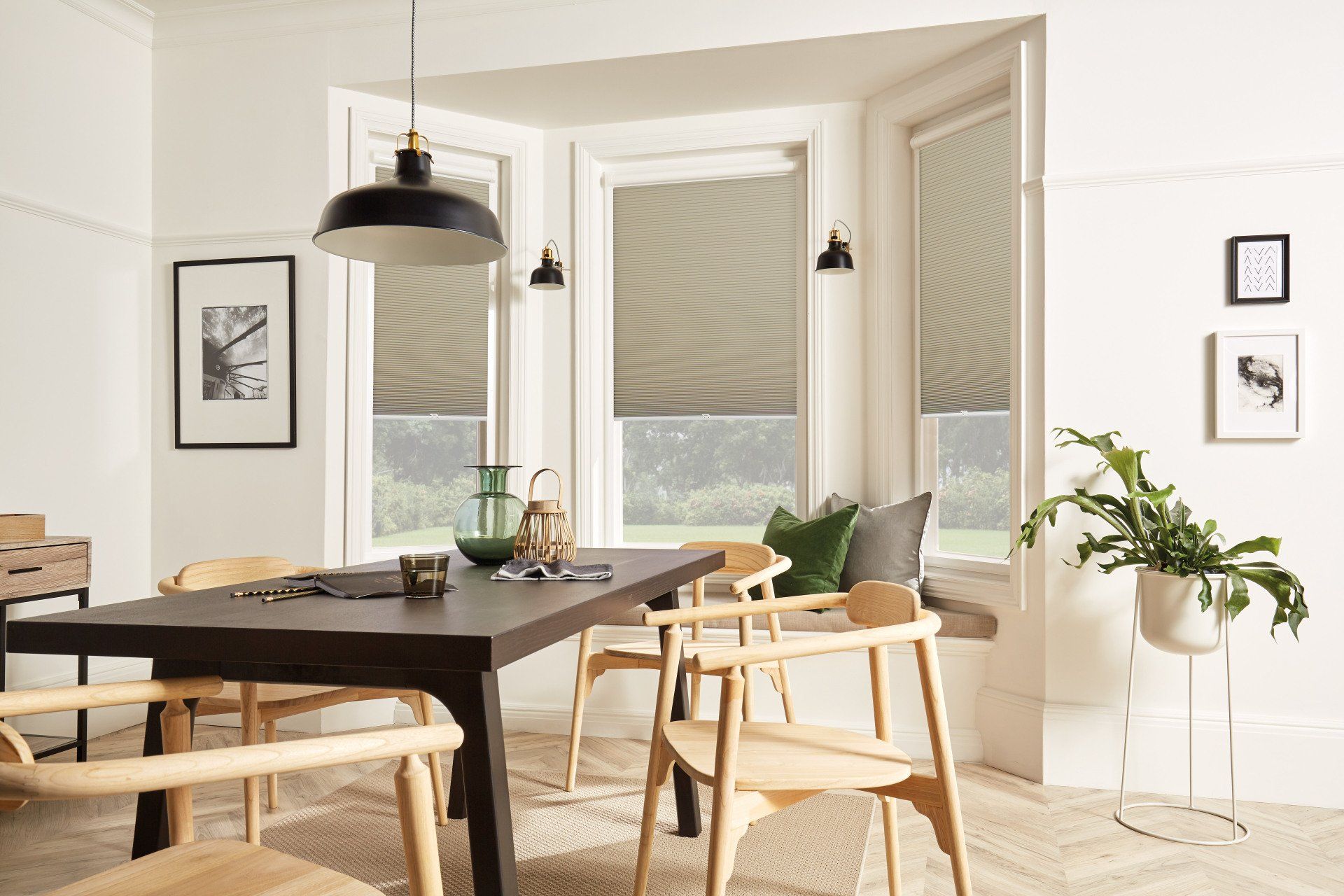 A dining room with a table and chairs and a window with blinds.