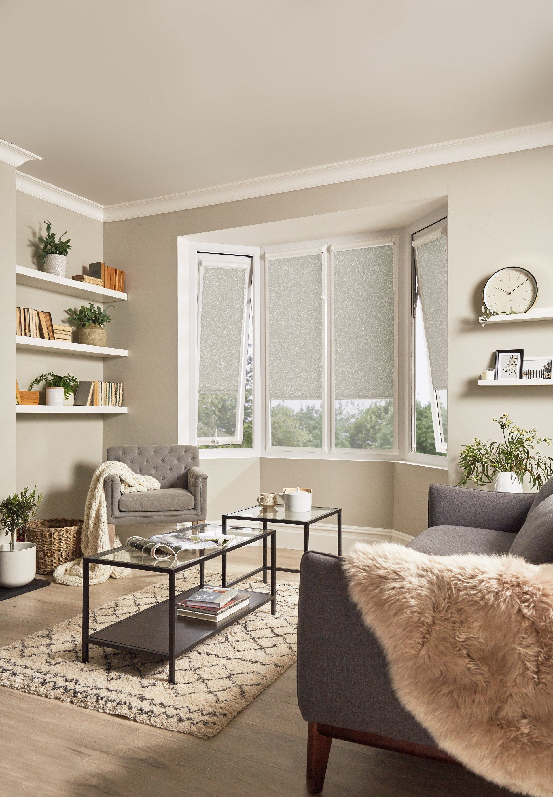 A living room with a couch , chair , coffee table and window.
