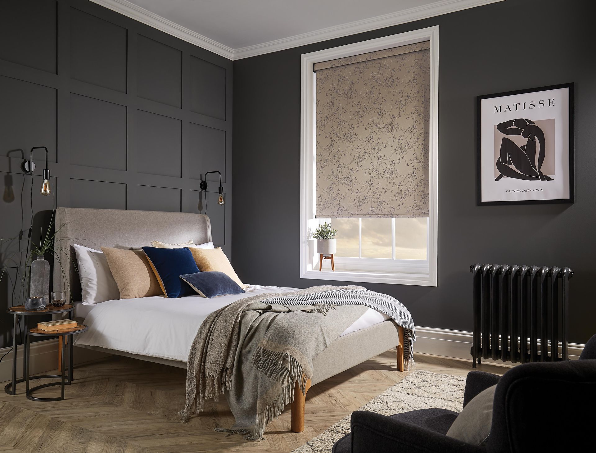 A bedroom with a bed , chair , table and window.