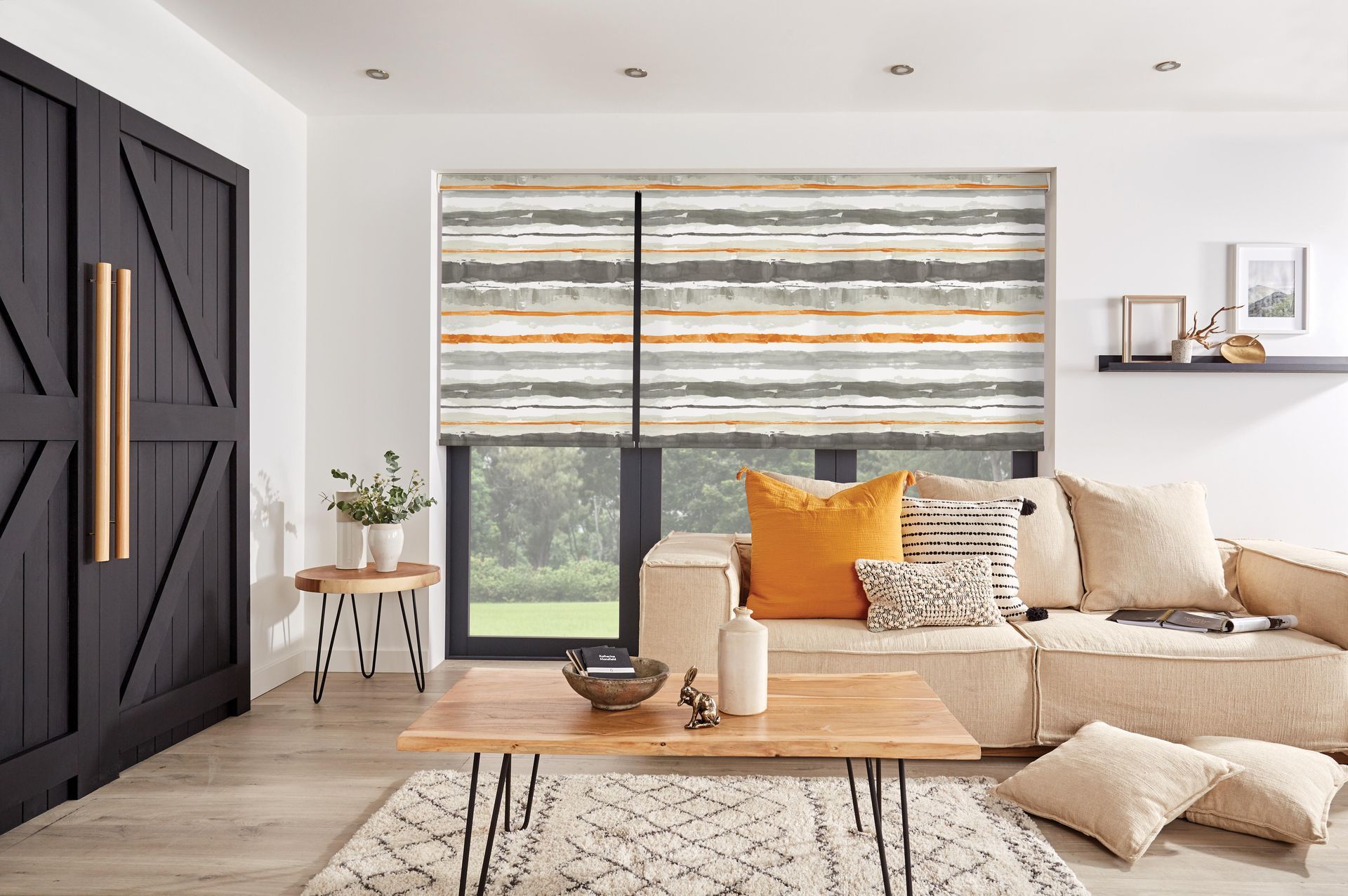 A living room with a couch , coffee table , and striped blinds.