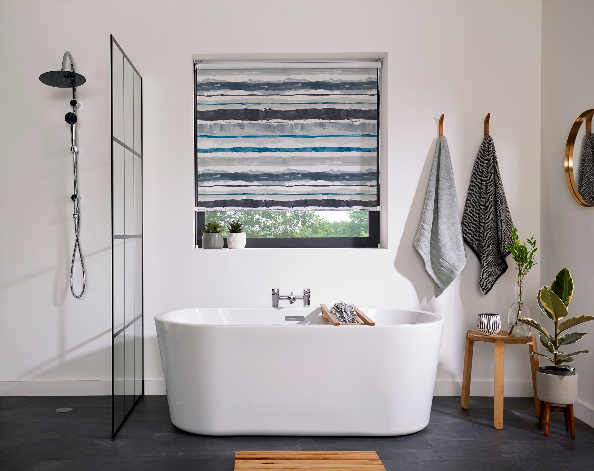 A bathroom with a bathtub , shower and window.