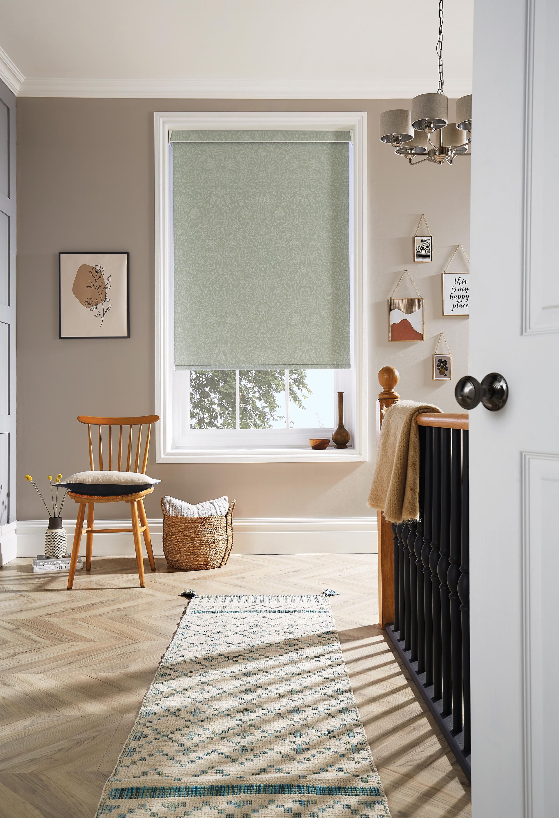 A room with a rug , chair , and window with a roller blind.