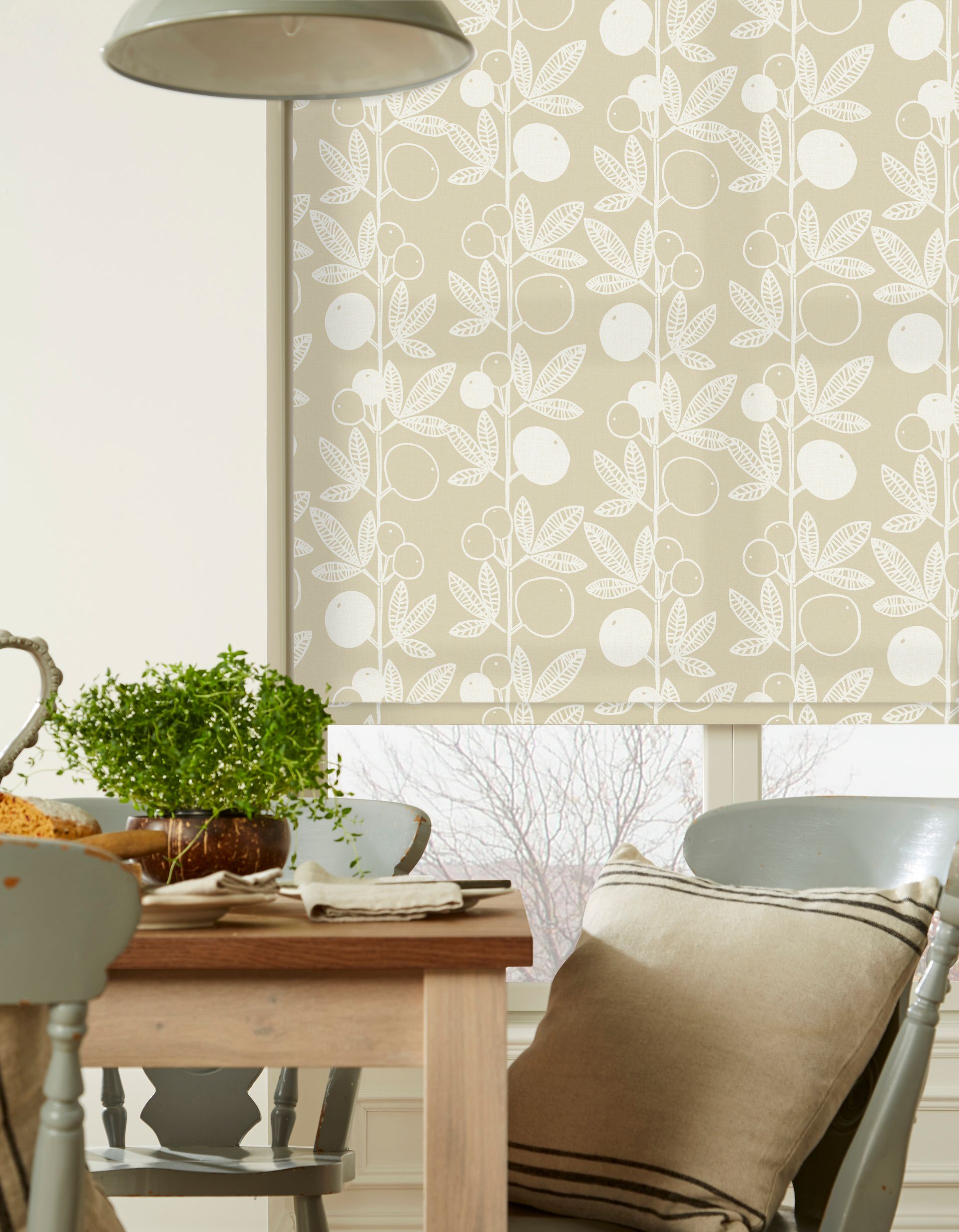 A dining room with a table and chairs and a window with a blind on it.