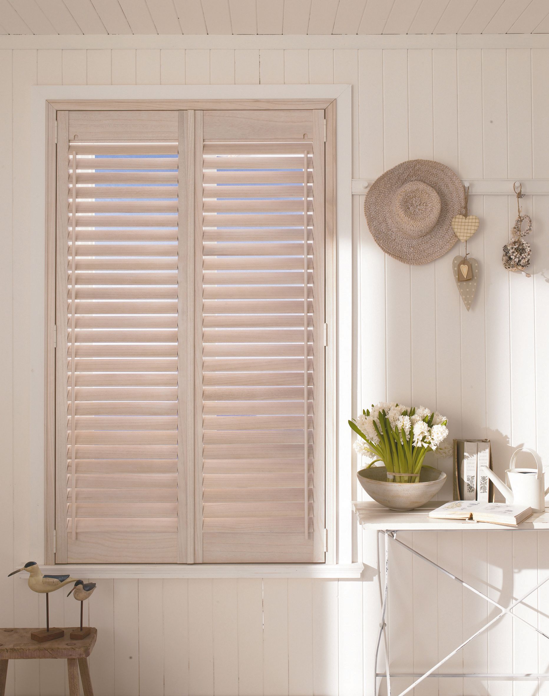 A white room with a window with shutters on it