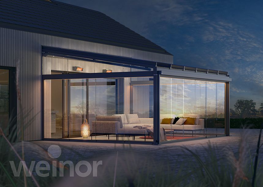 A house with a pergola and a couch in front of it.