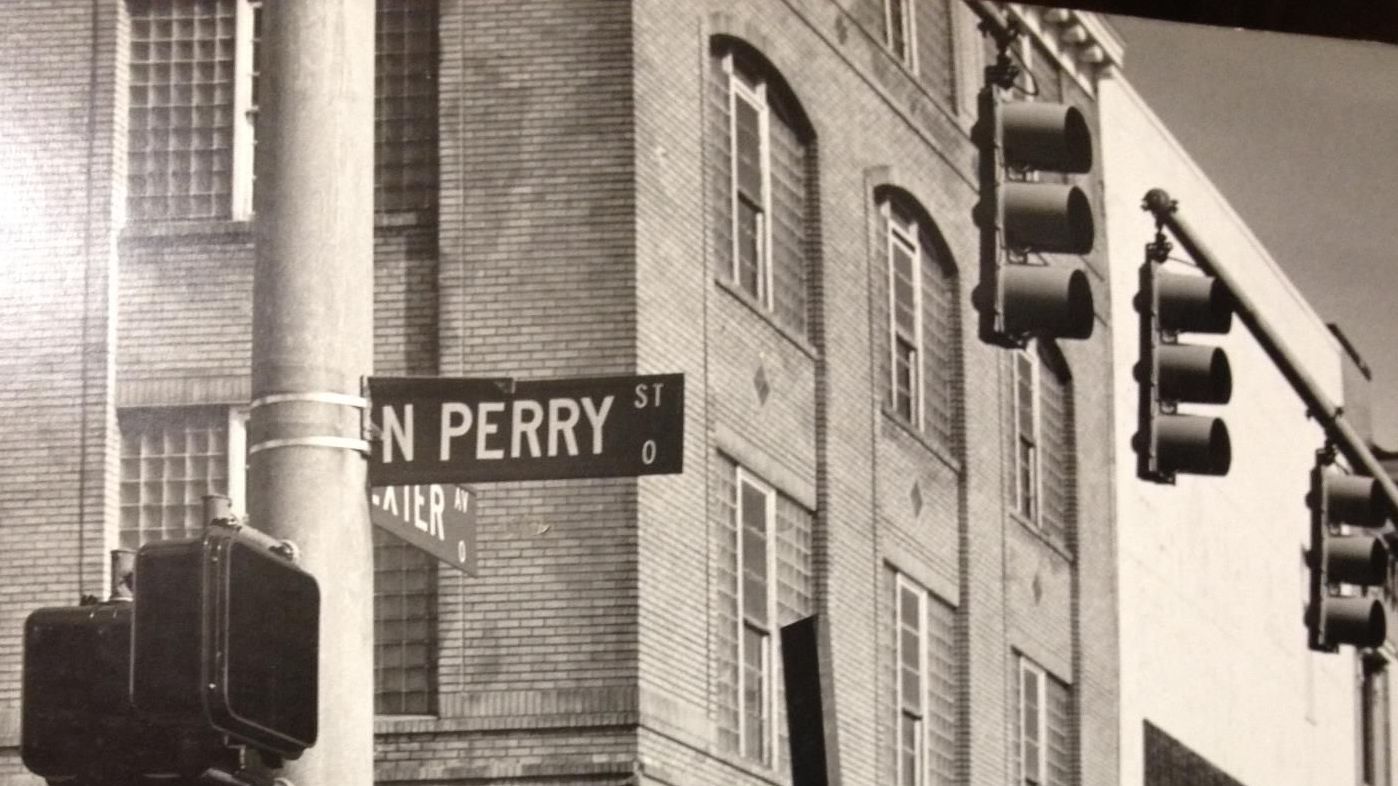 A black and white photo of a street sign for north perry street, montgomery, al