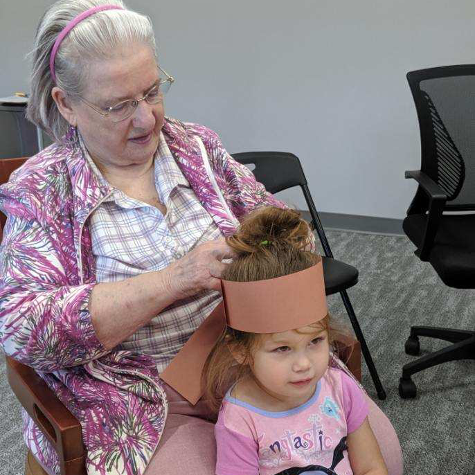 resident helping child put on a hat