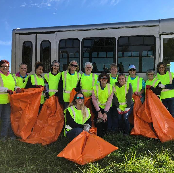 group of employees volunteering to clean ditches along a highway