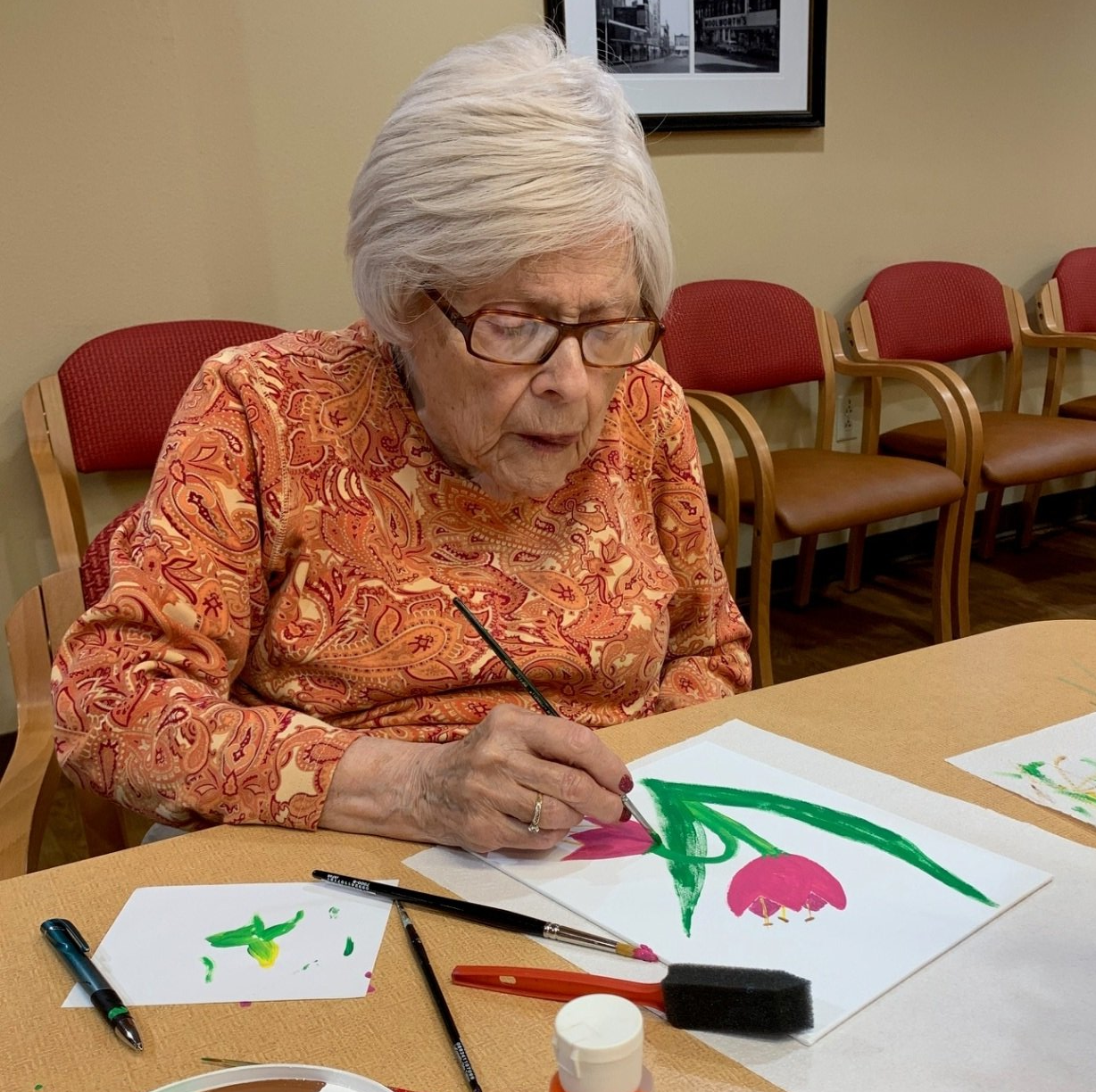 senior living resident painting flowers on paper