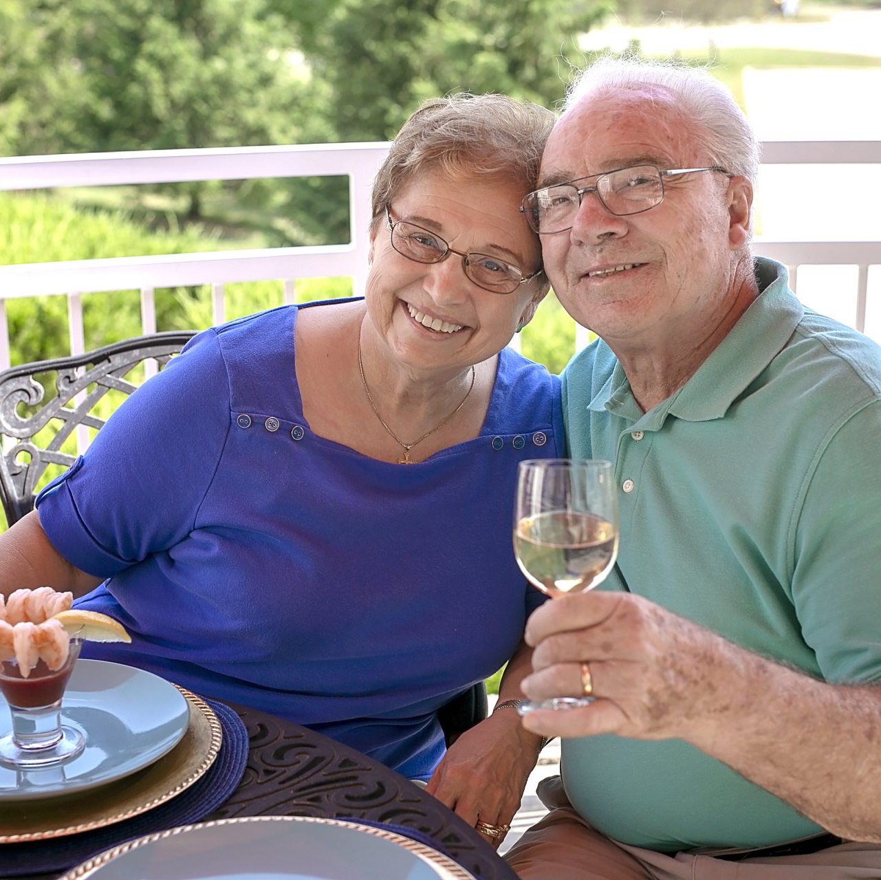 Couple drinking wine and eating appetizers outside on the patio of Landmark Commons dining room