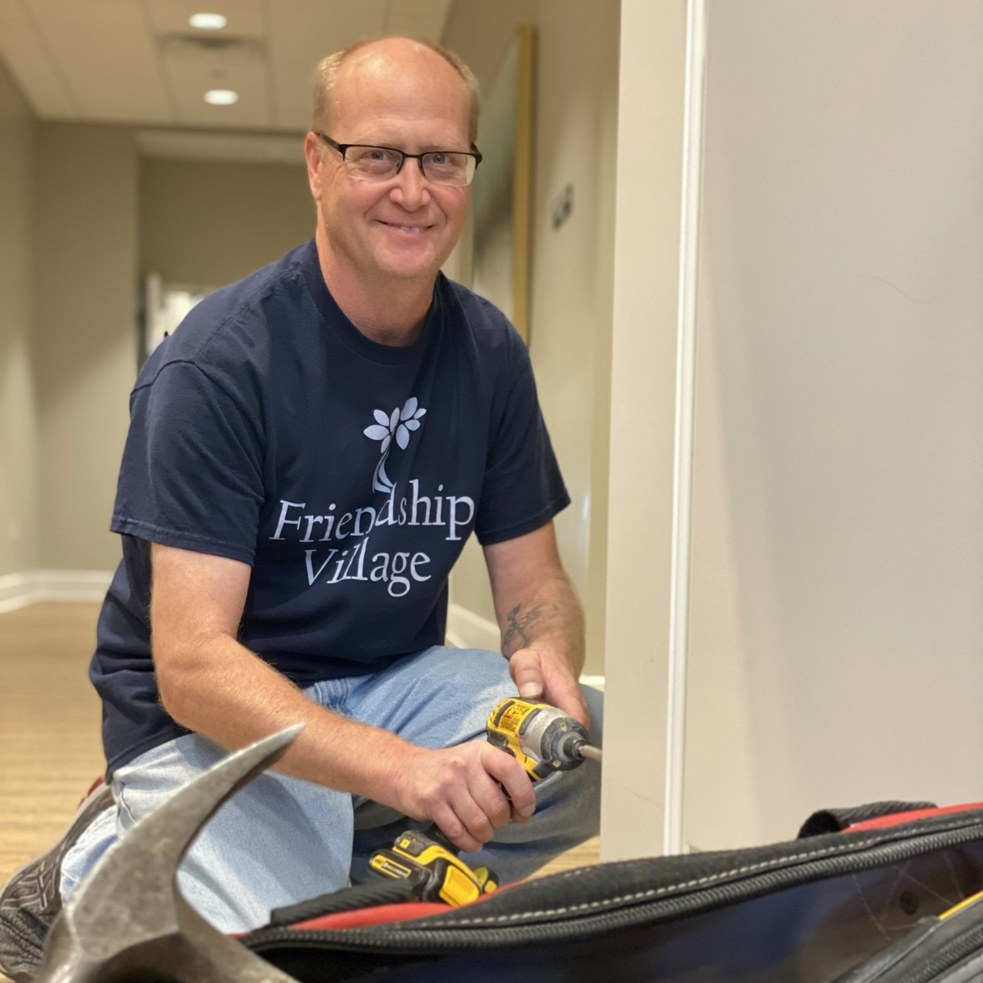 Maintenance worker fixing a door hinge to a residents apartment