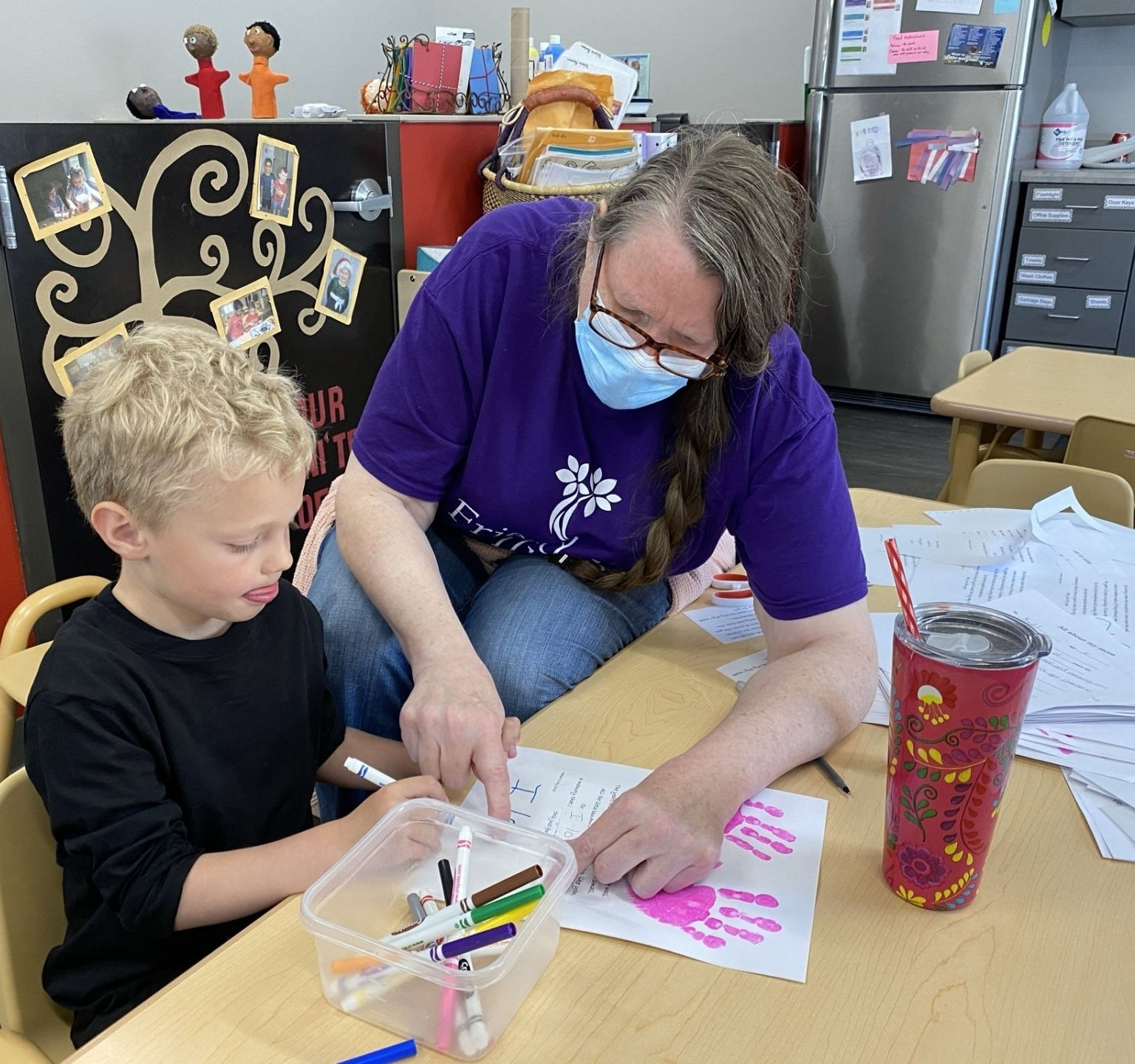 teacher helping young boy learn during a learning session at the childcare center
