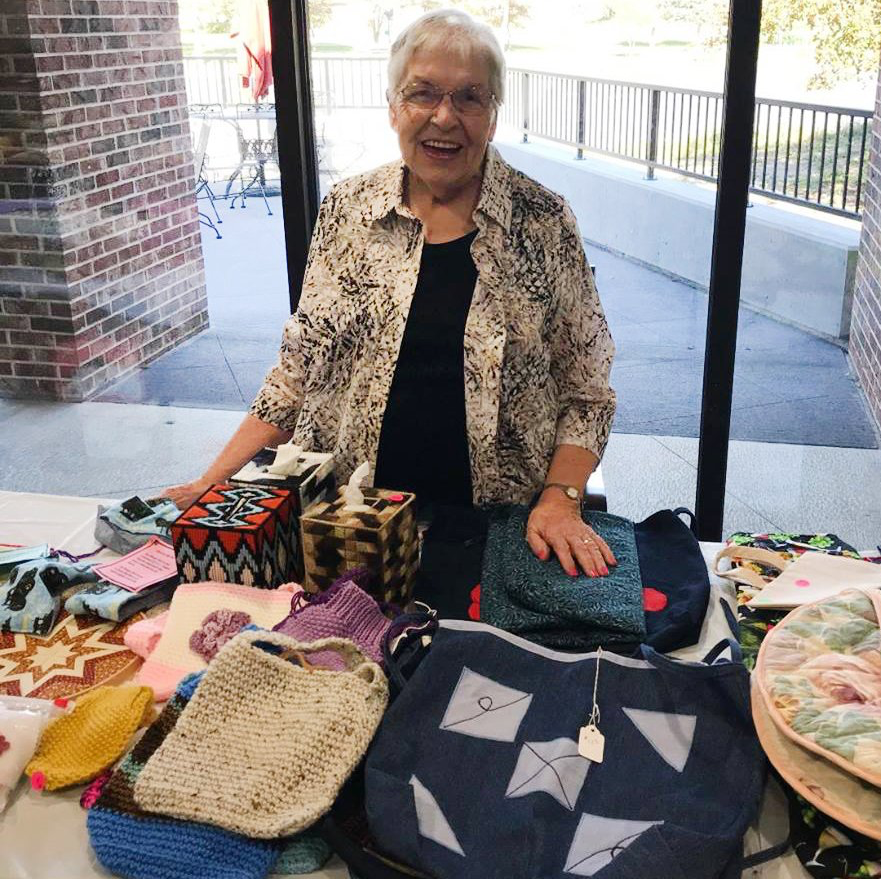 Resident displaying craft items at the fall craft sale