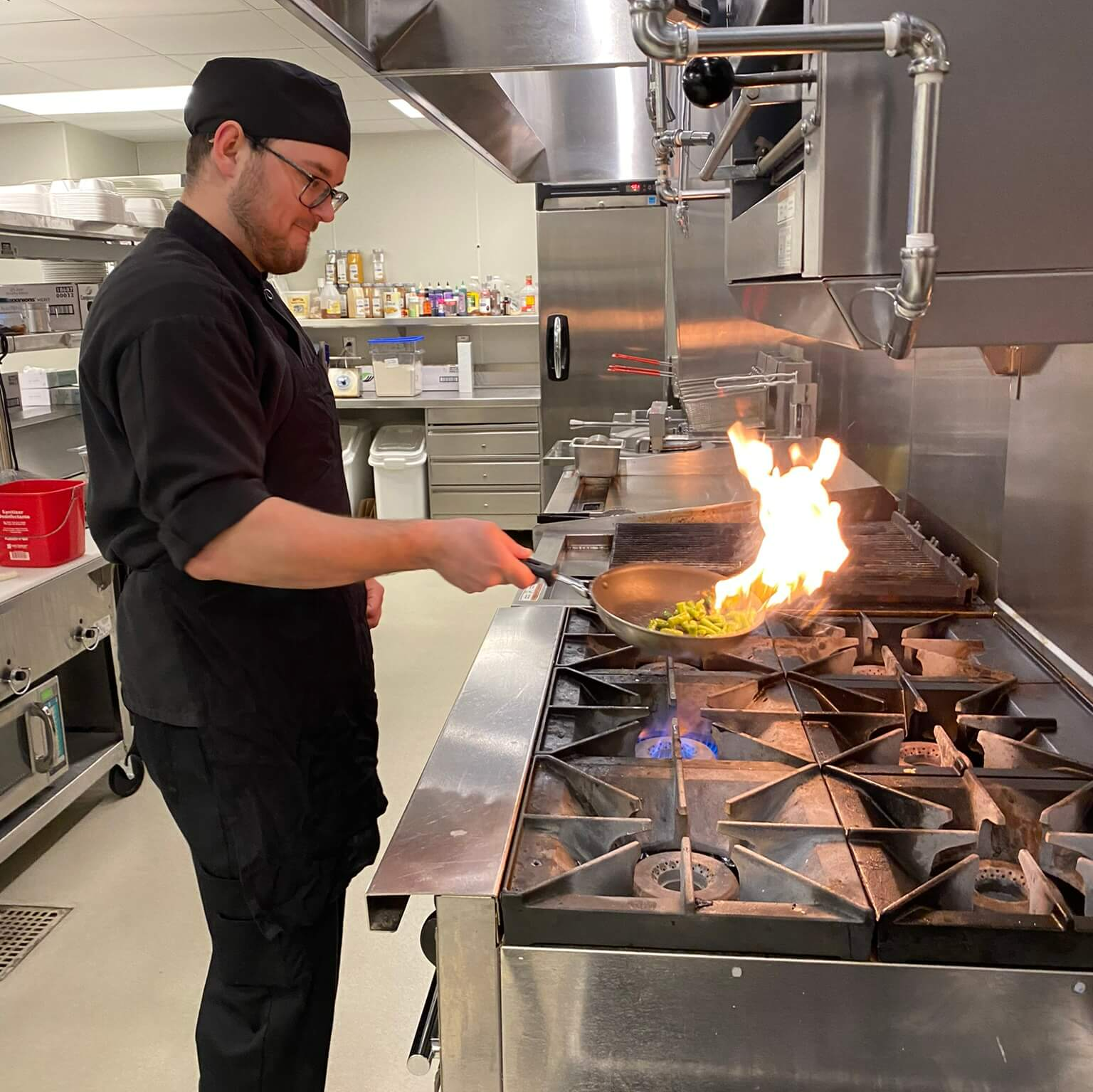 chef making flames while cooking on the stove
