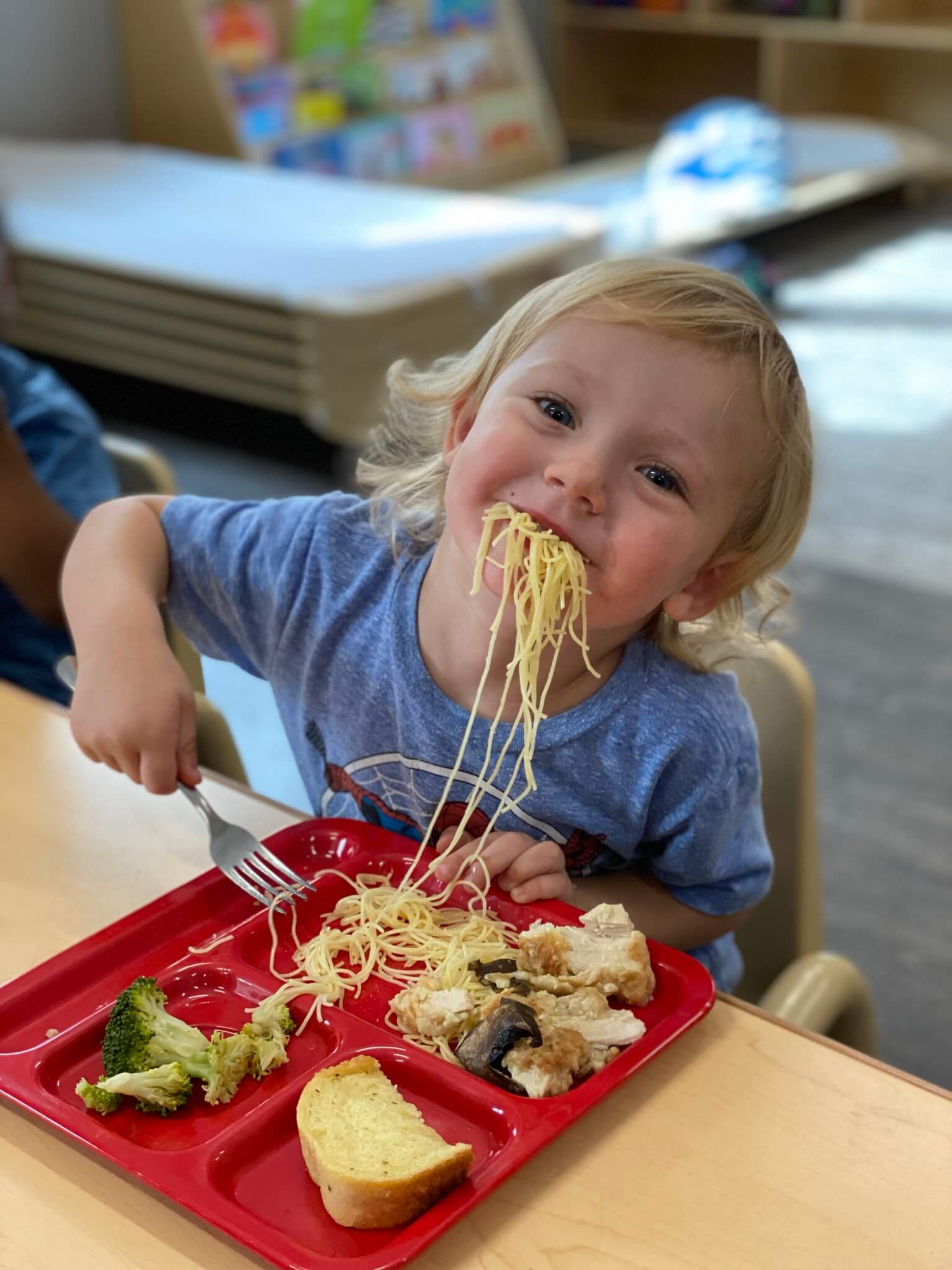 child eating with spaghetti hanging out of his mouth