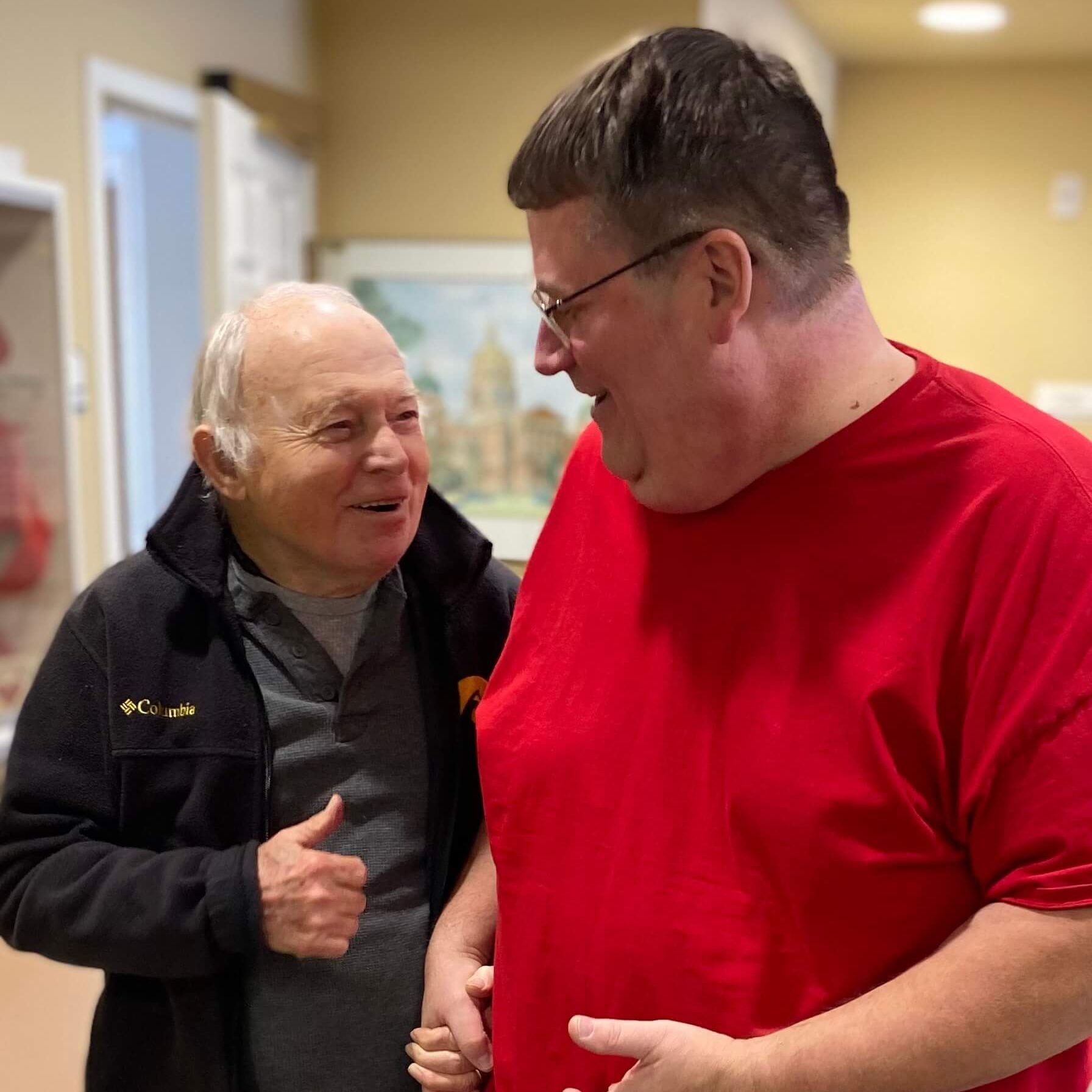 Assisted living resident and caregiver walking down the hallway