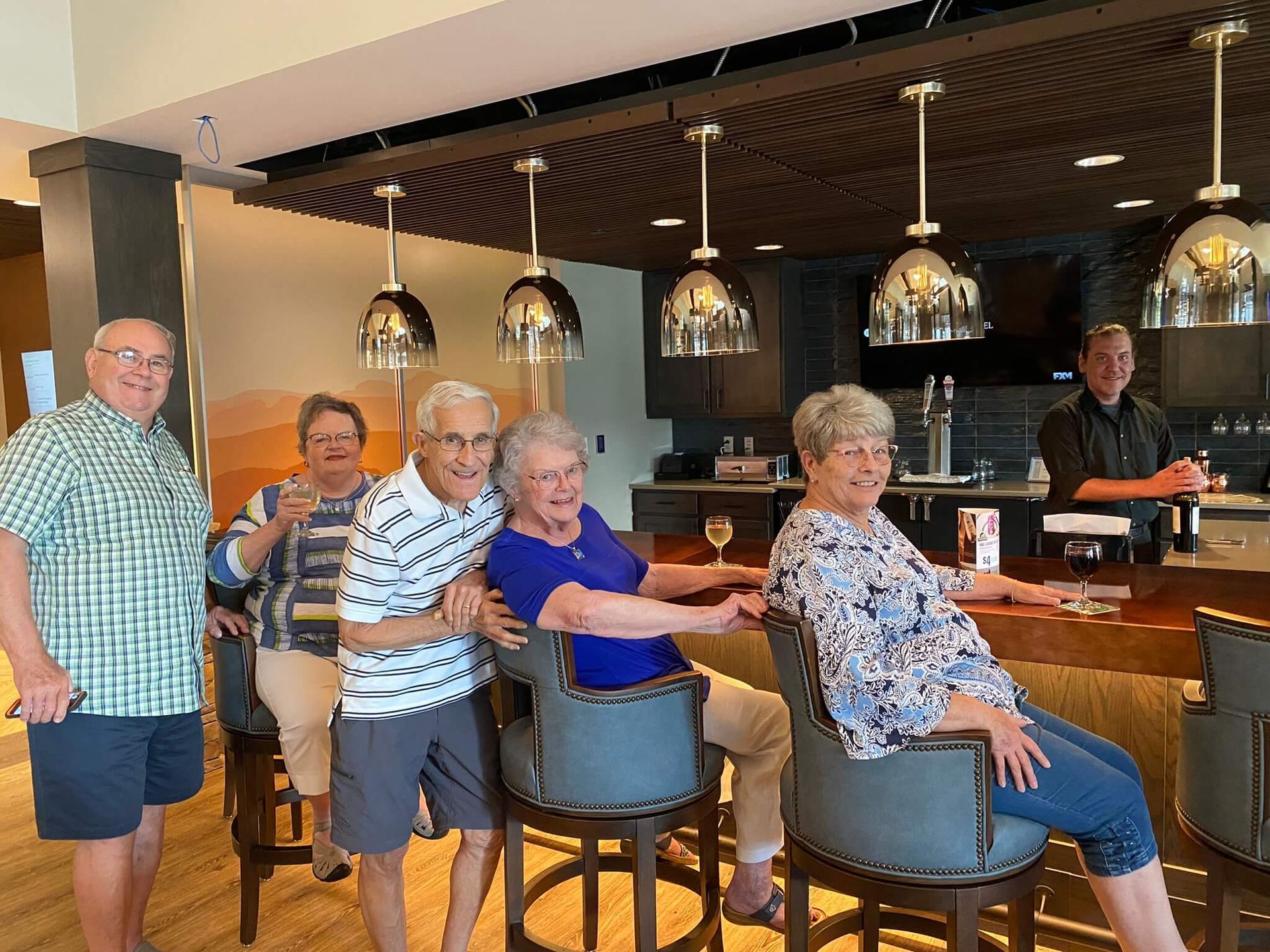 Active group of residents playing Scrabble and eating an assortment of snacks Active group of Friendship Village residents mingling and playing Scrabble in the Cove Lounge