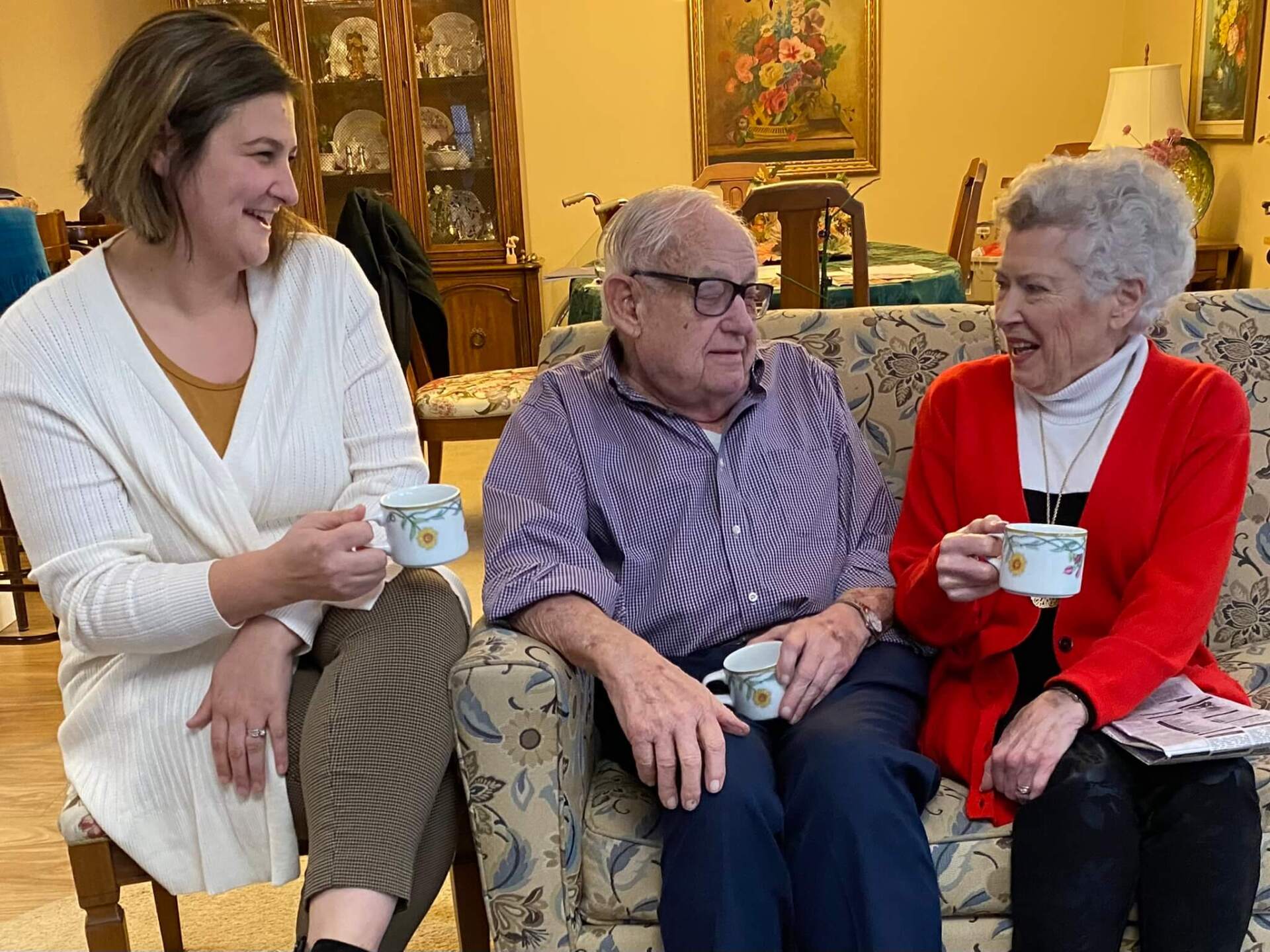 Friends At Home employee conversing and sipping coffee with residents