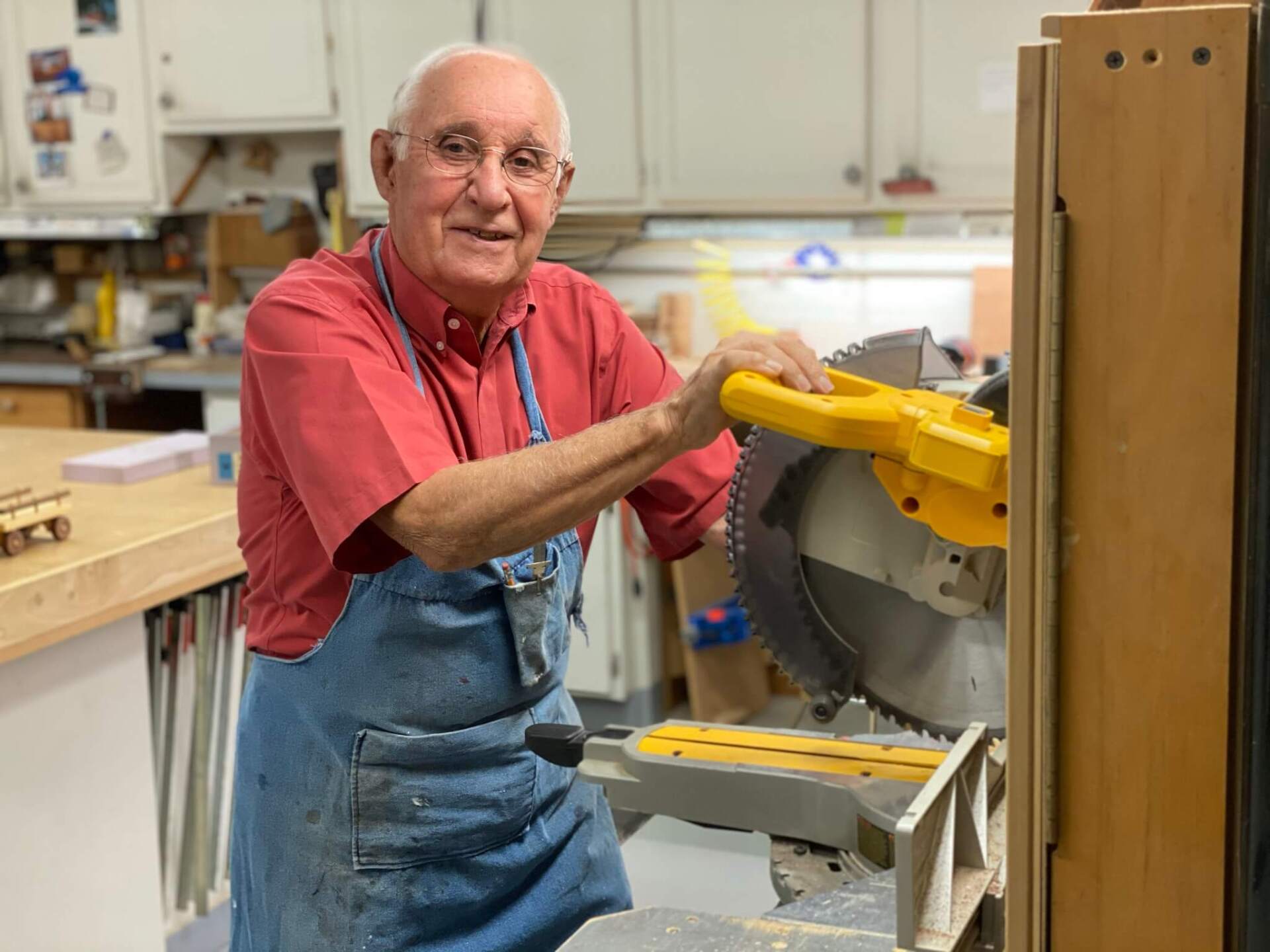independent living resident using a saw in the Landmark Commons woodshop