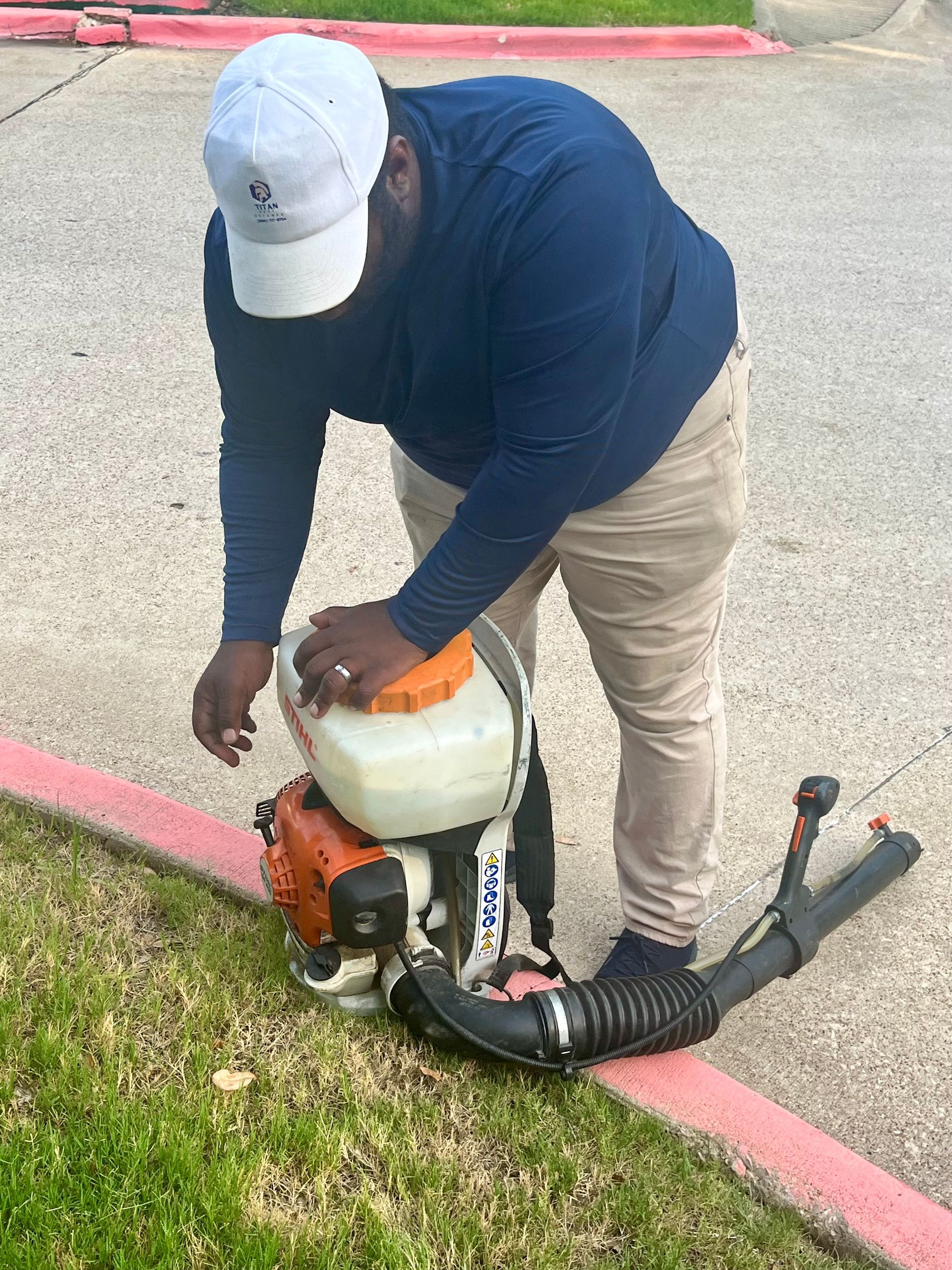 A man is standing next to a stihl backpack blower