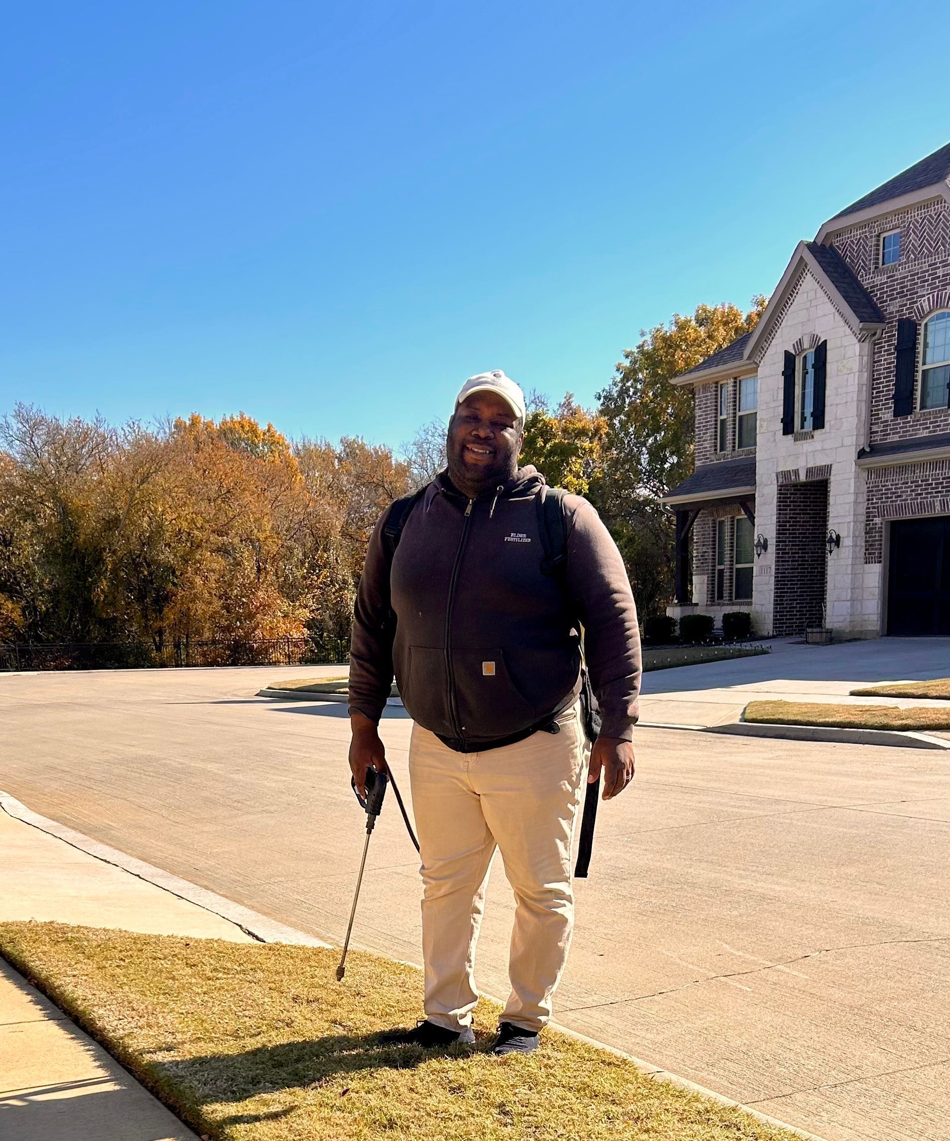 A man is standing on a sidewalk in front of a house .
