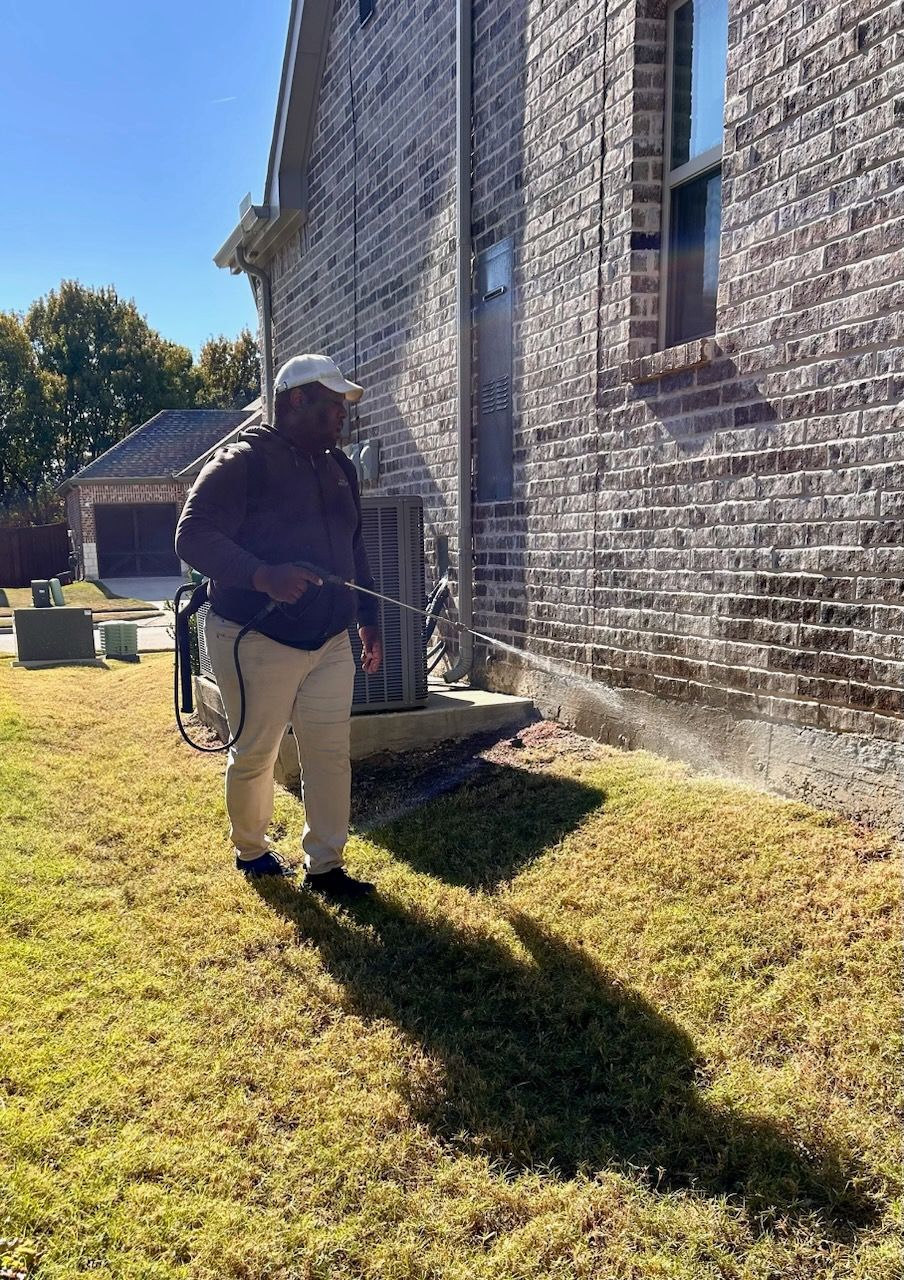 A pest control technician is treating a foundation for ant control in Lewisville, TX.