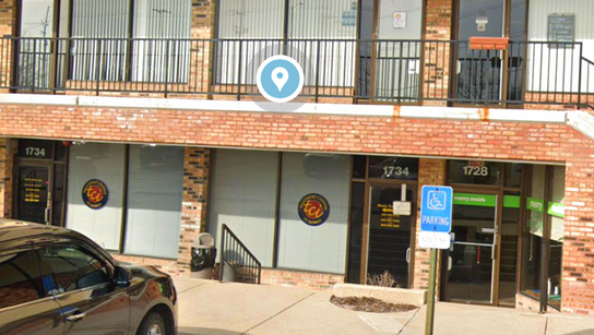 A car is parked in front of a brick building.
