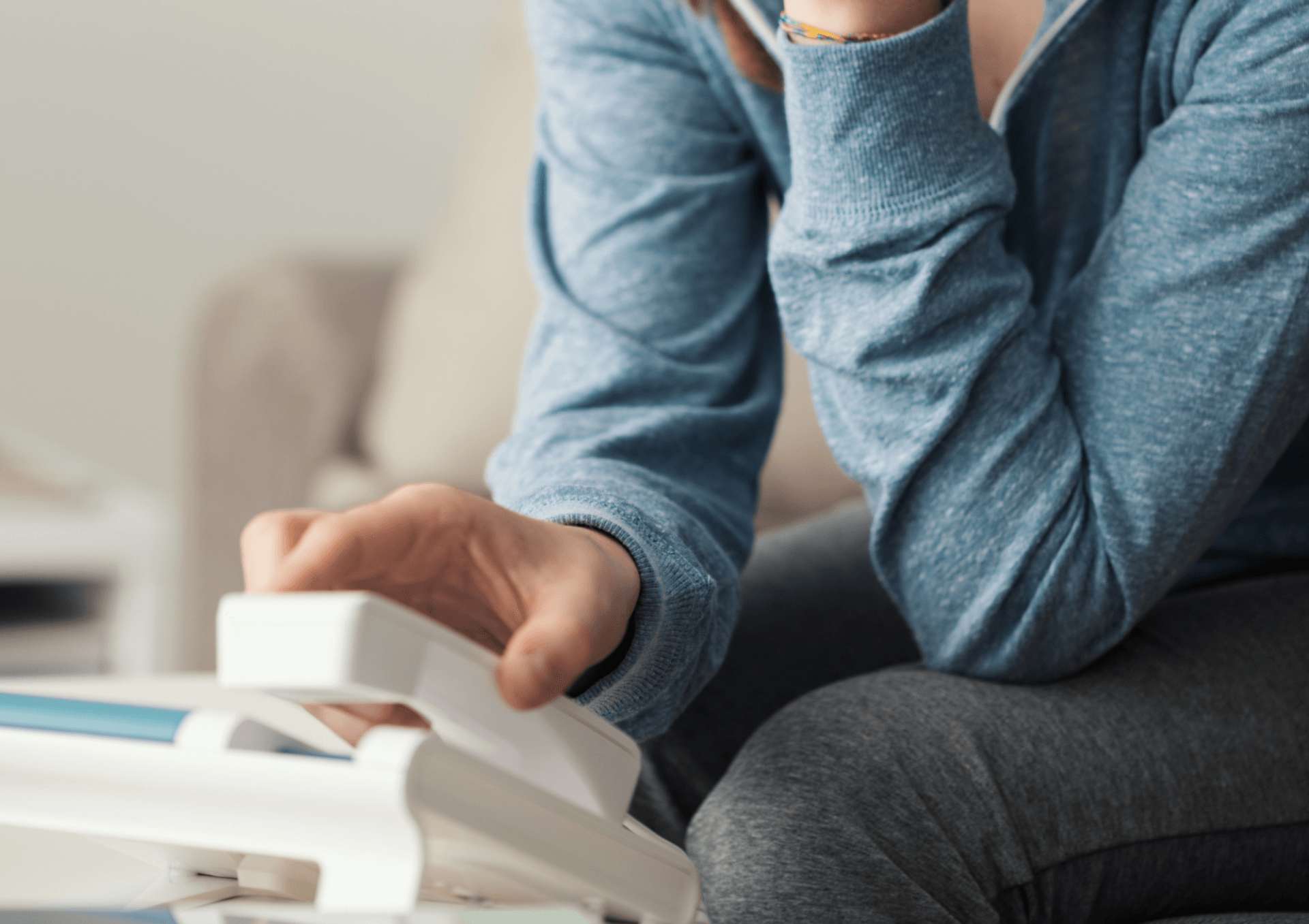 A woman is sitting on a couch talking on a telephone.