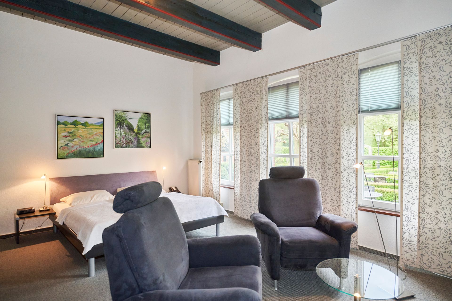 Ein Schlafzimmer mit einem Bett, Stühlen und einem Tisch.