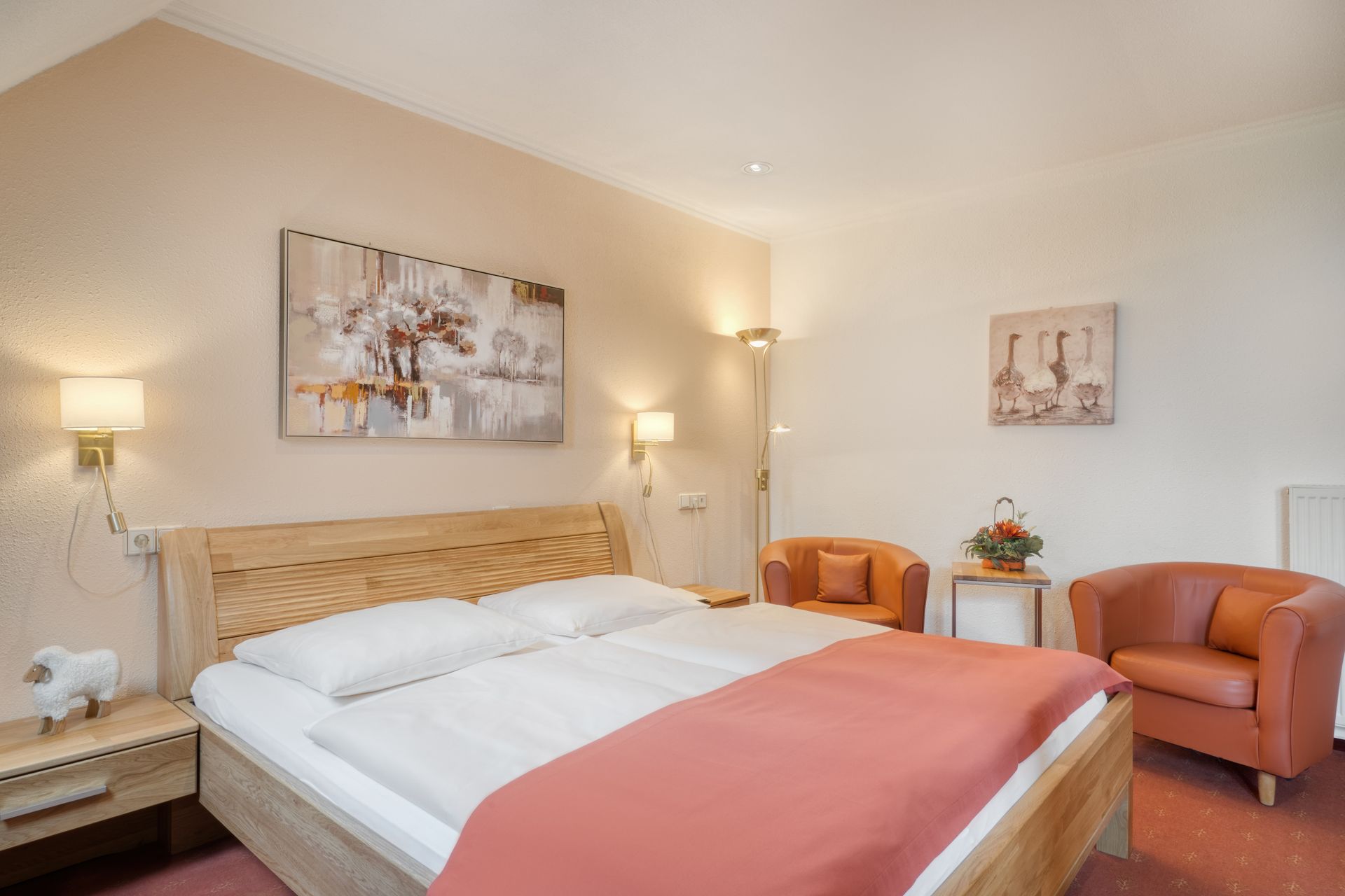 Ein Hotelzimmer mit einem Bett, einem Stuhl, einem Nachttisch und einem Gemälde an der Wand.