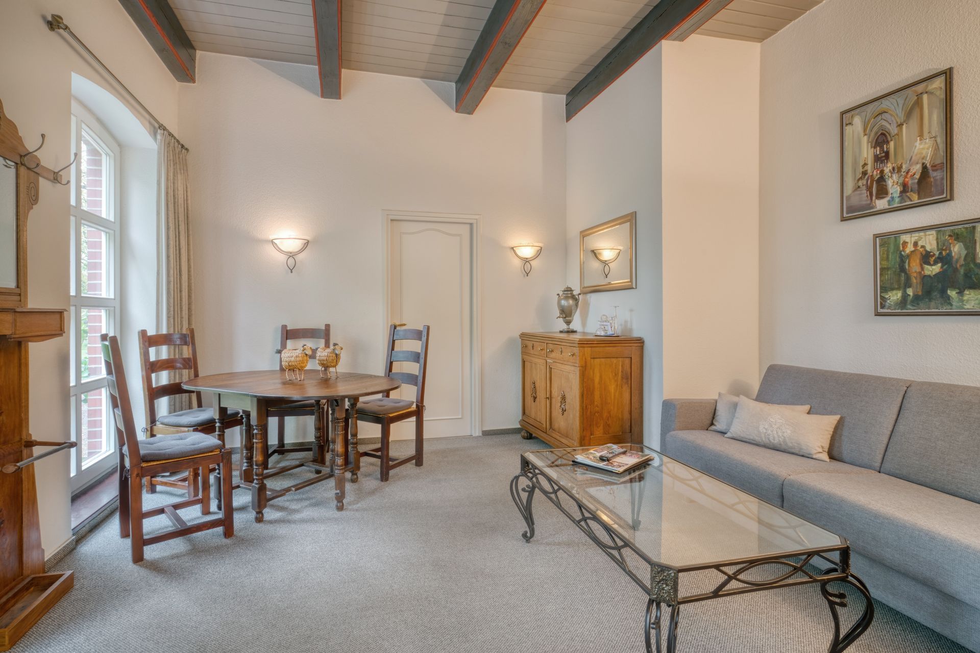 Ein Wohnzimmer mit Sofa, Tisch und Stühlen.