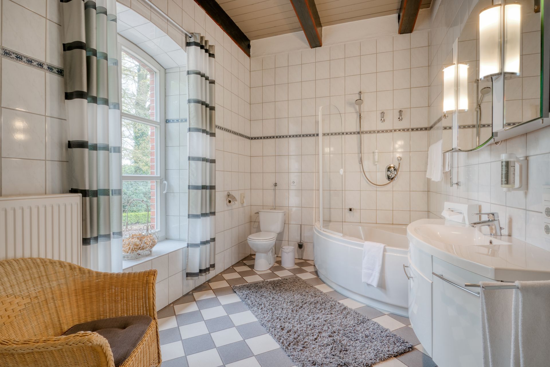 Ein Badezimmer mit Badewanne, Waschbecken, Toilette und Stuhl.