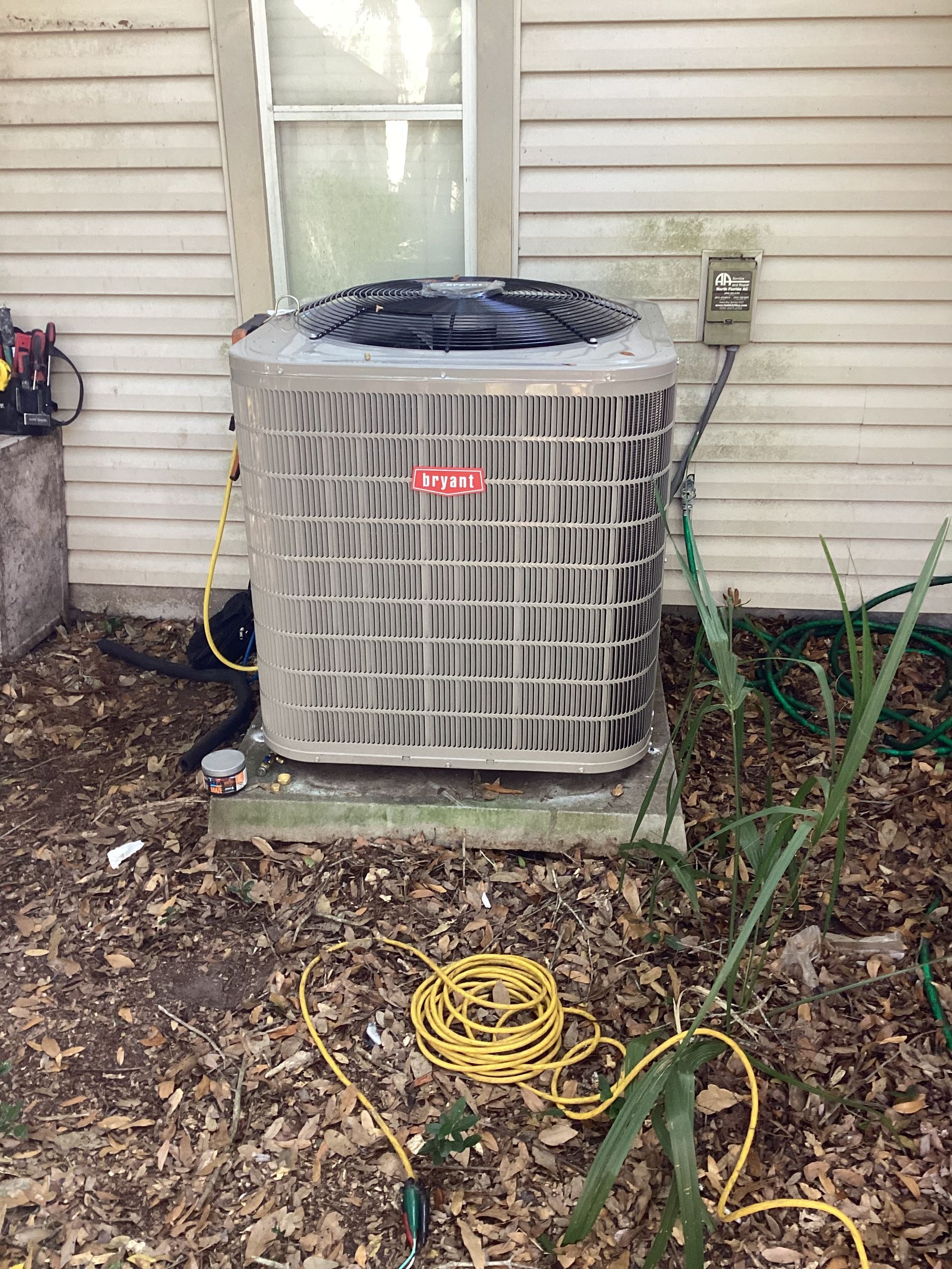 Hand installing a small white device on a wall-mounted air conditioner unit.