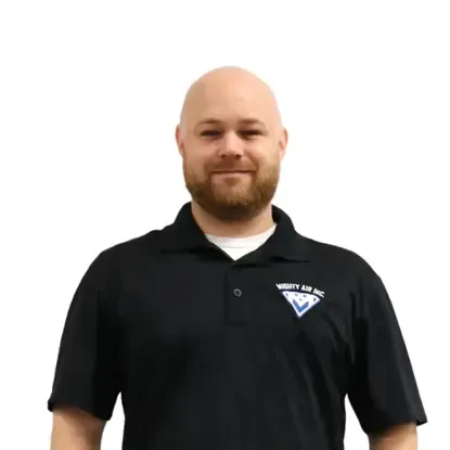 Smiling bald man in a black polo shirt with a logo on the chest, standing against a white background