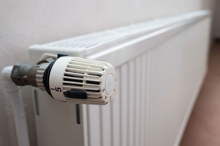 White radiator with a thermostatic valve in a bright room