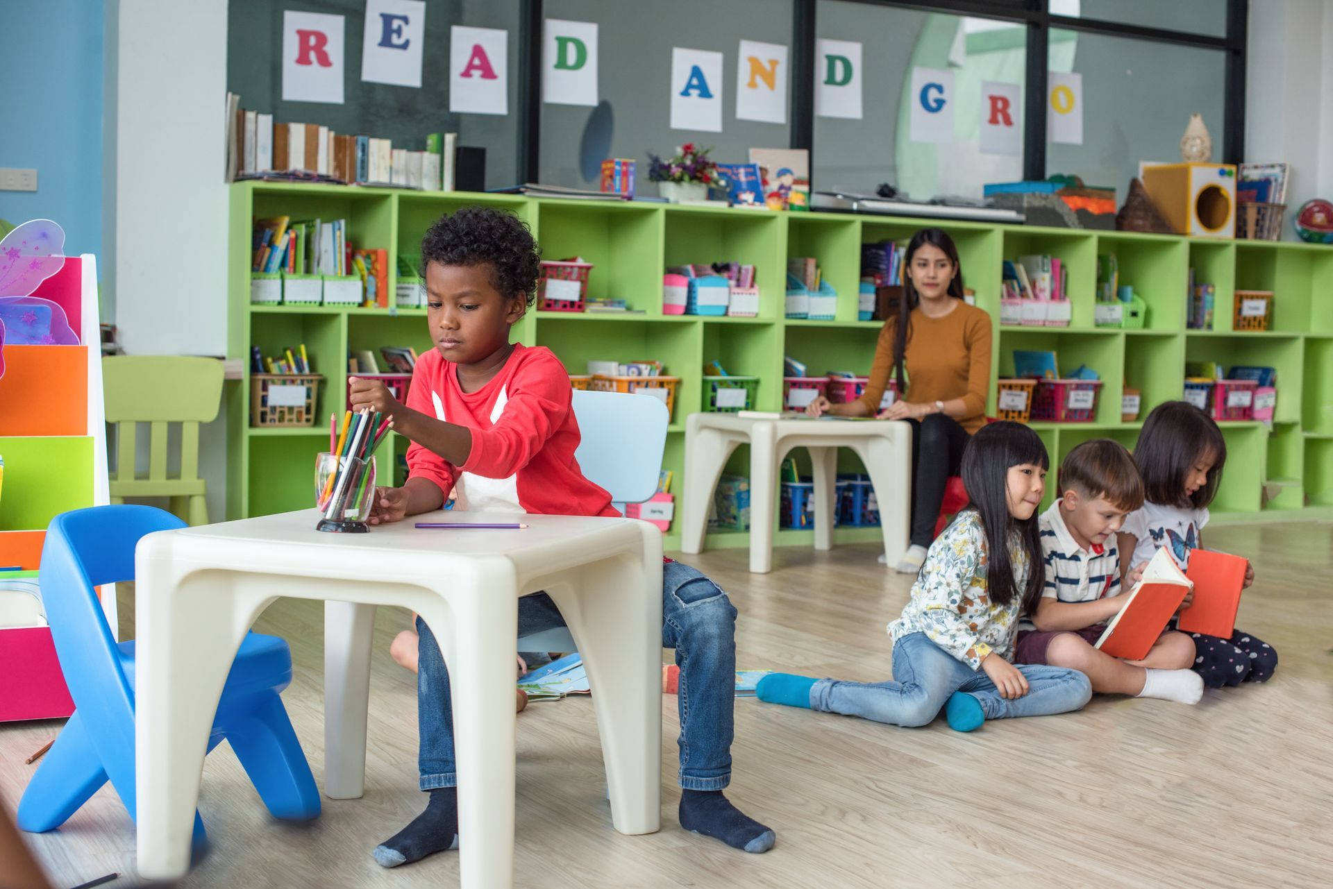 Young children focused on a drawing and reading activities during preschool class. Young children focused on a drawing and reading activities during preschool class.