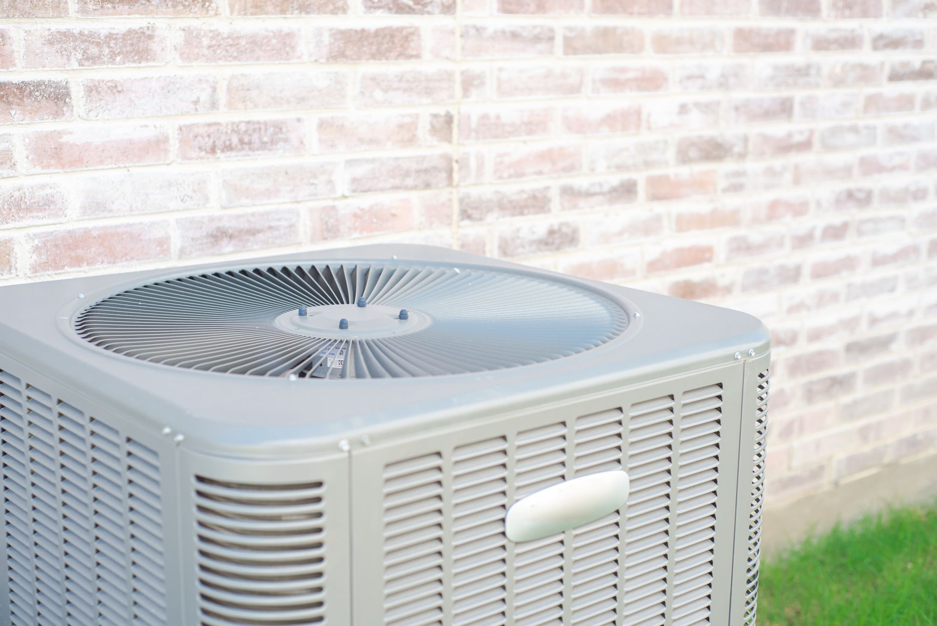 Person wearing gloves uses a screwdriver to repair a white air conditioner.