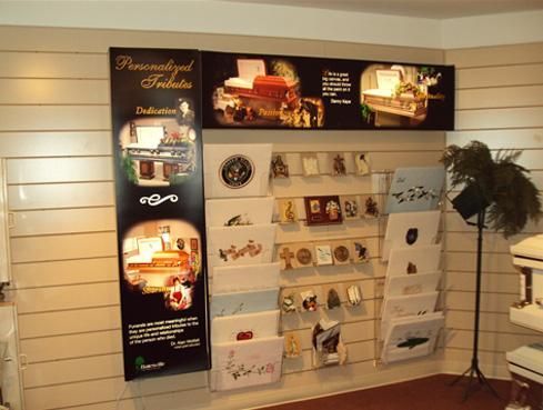 Brochure display rack against a white slat wall, with black and white travel posters and pamphlets