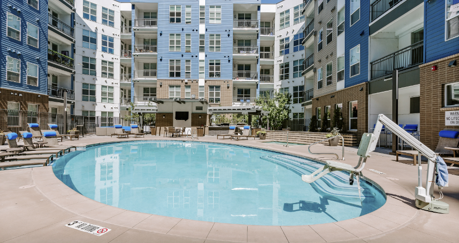 There is a large swimming pool in the middle of a building.