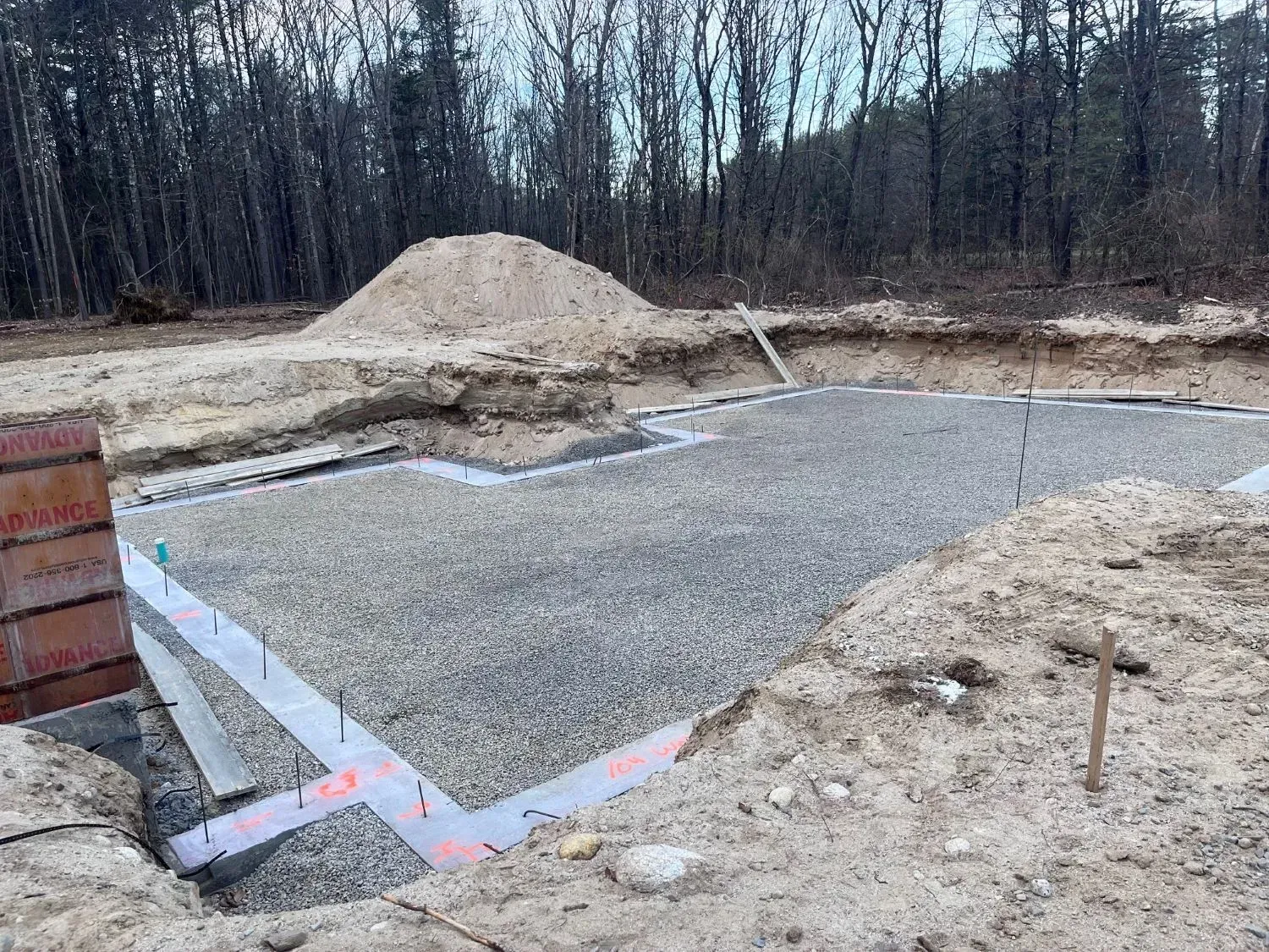 A construction site with a lot of dirt and trees in the background.