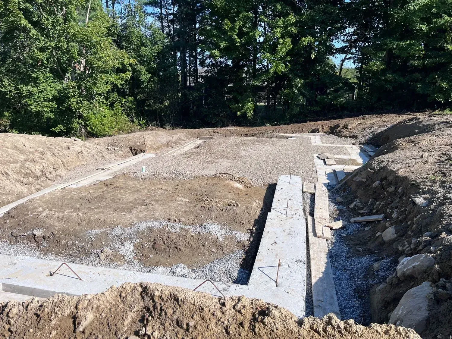 A construction site with a lot of dirt and trees in the background