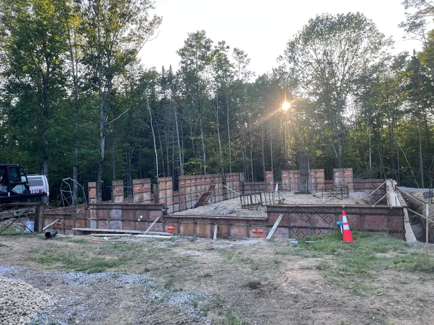 A construction site with a lot of concrete and trees in the background.