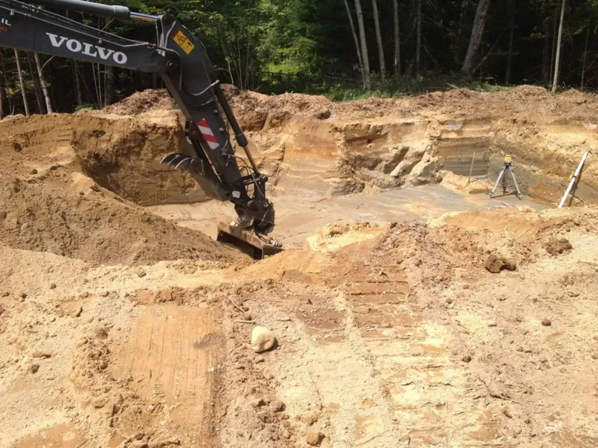 A volvo excavator is digging a hole in the dirt.