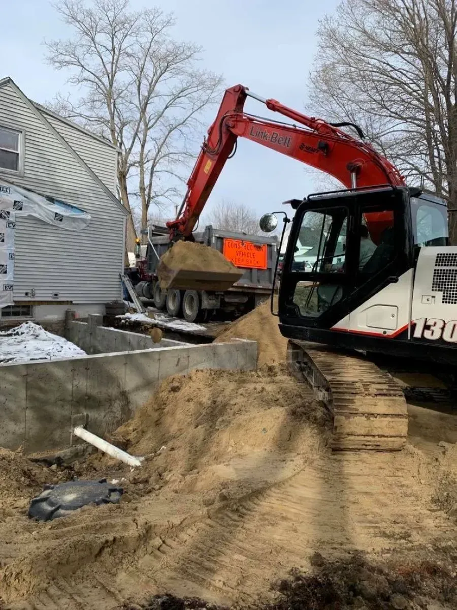 A large excavator is loading dirt into a dump truck.