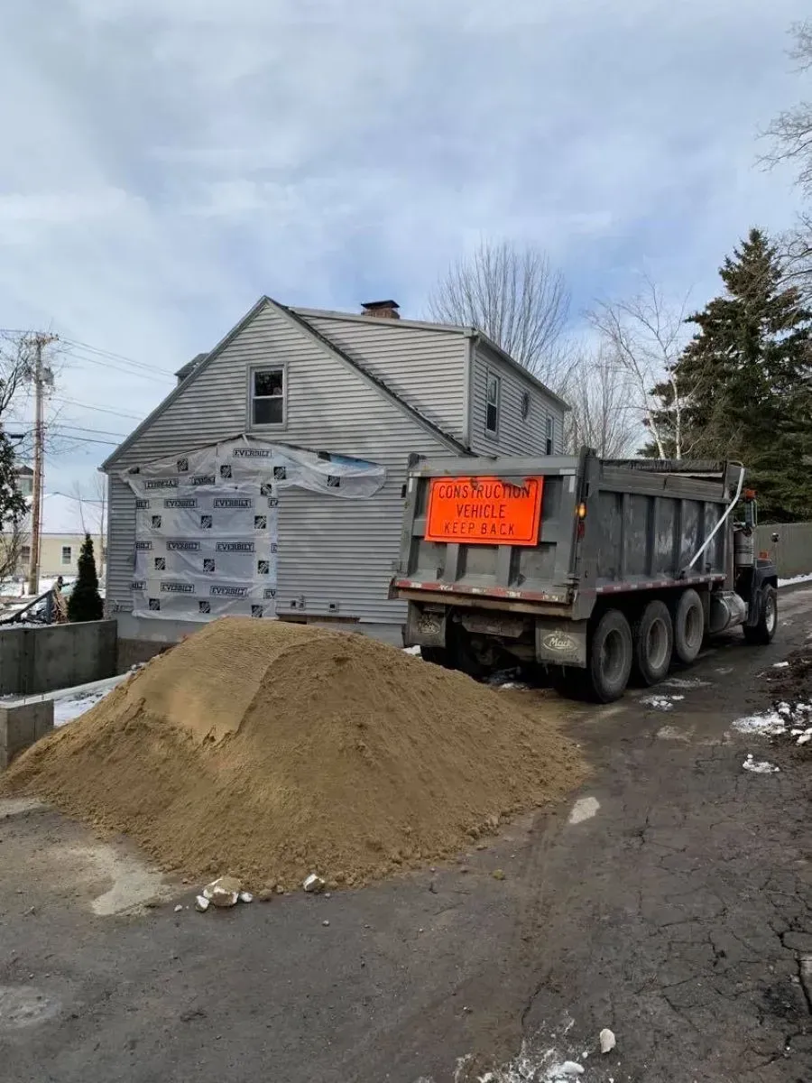 A dump truck is parked in front of a house.