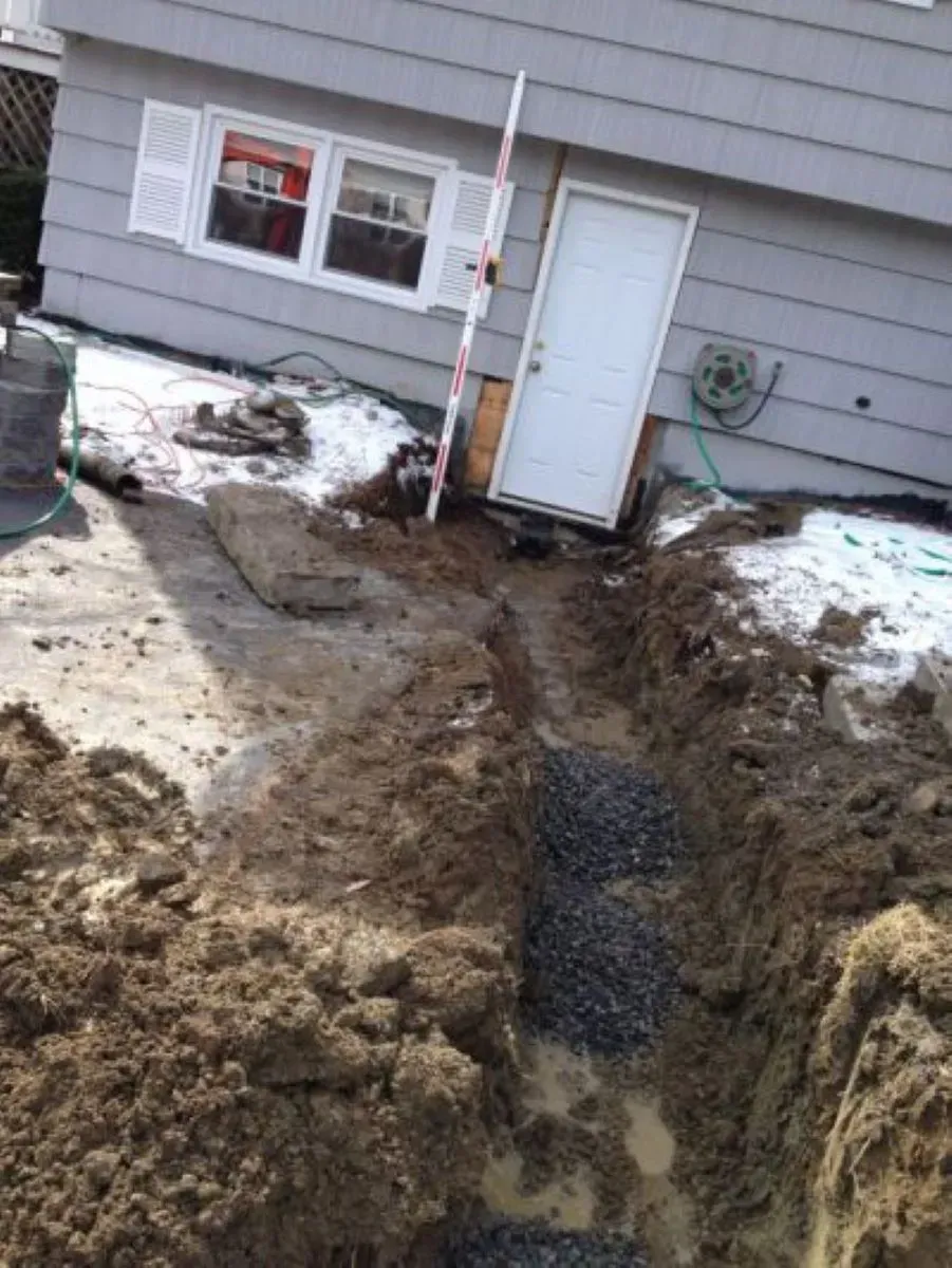 A house with a hole in the ground in front of it